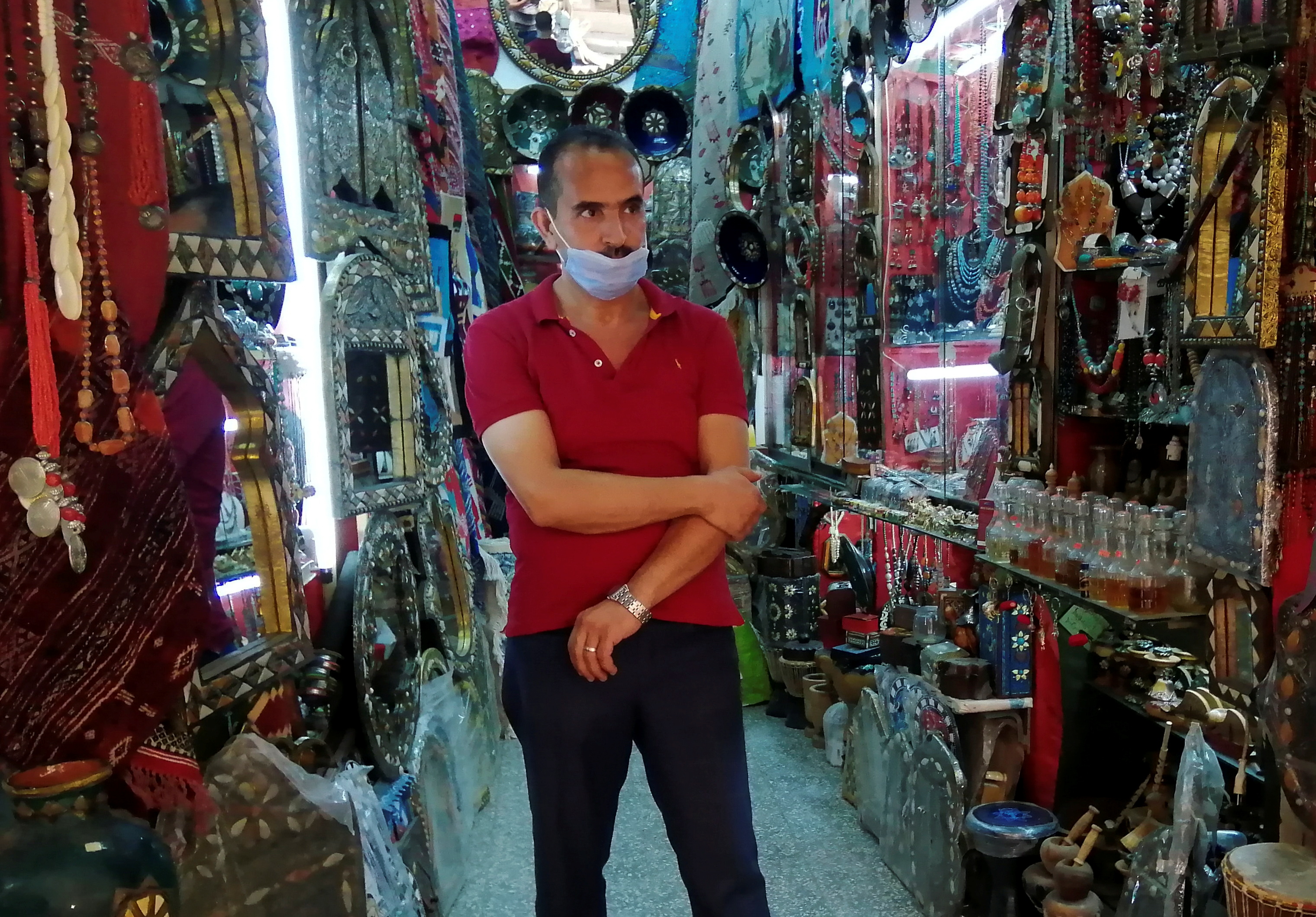 Abdesattar Massoudi, the owner of an artisanal store, attends an interview with Reuters inside his shop in the tourist bazaar in the Old City of Tunis
