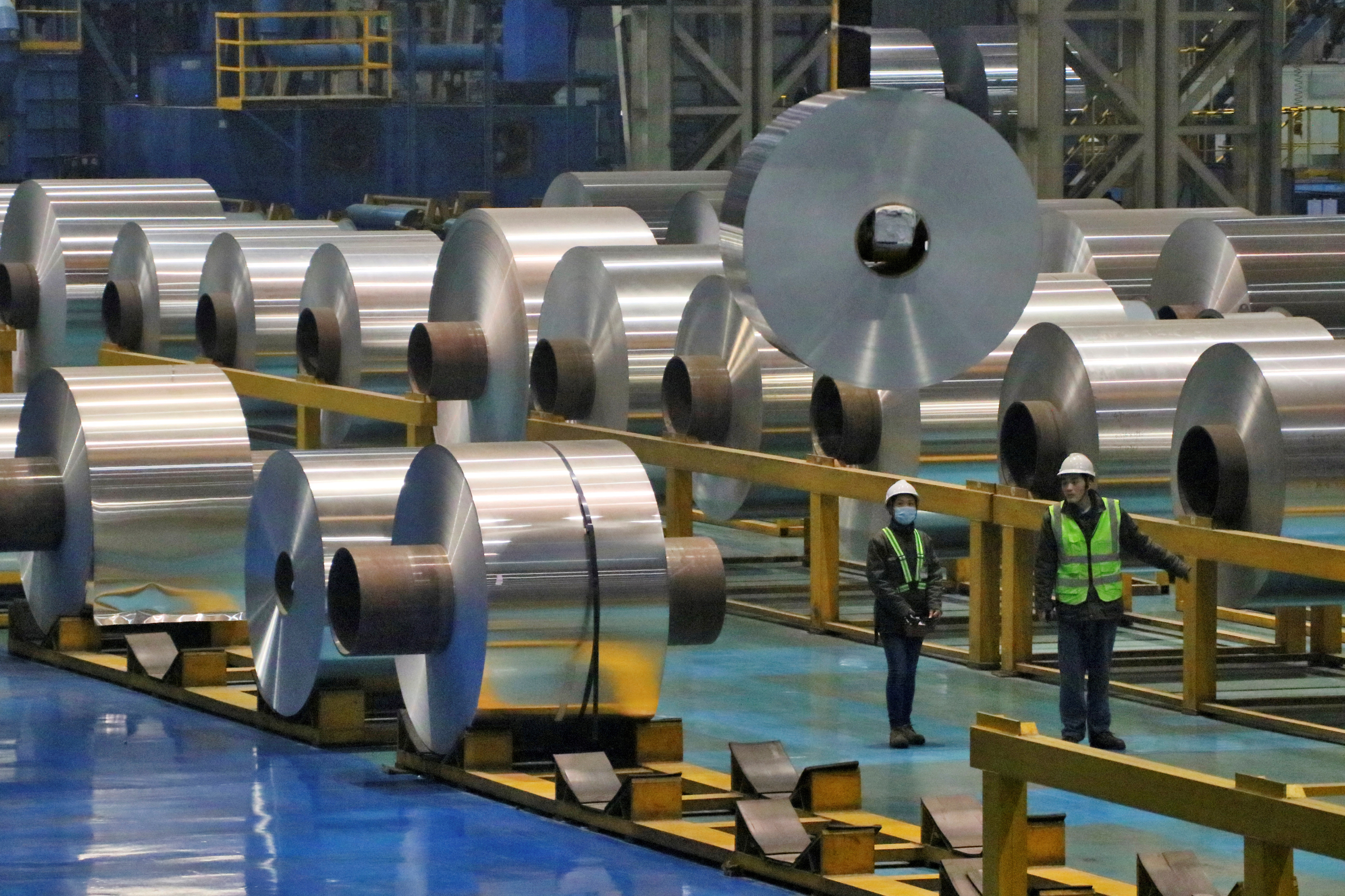 Employees work at the production line of aluminium rolls at a factory in Zouping