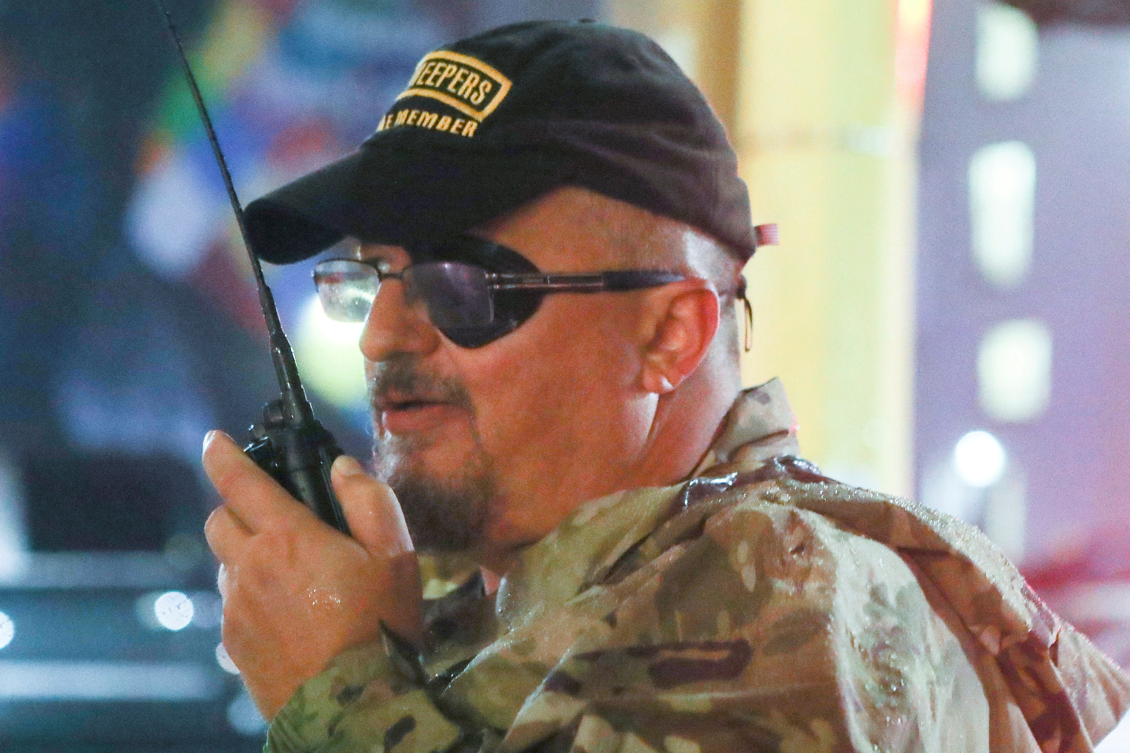 Stewart Rhodes of the Oath Keepers uses a radio as he departs a Trump rally in Minneapolis