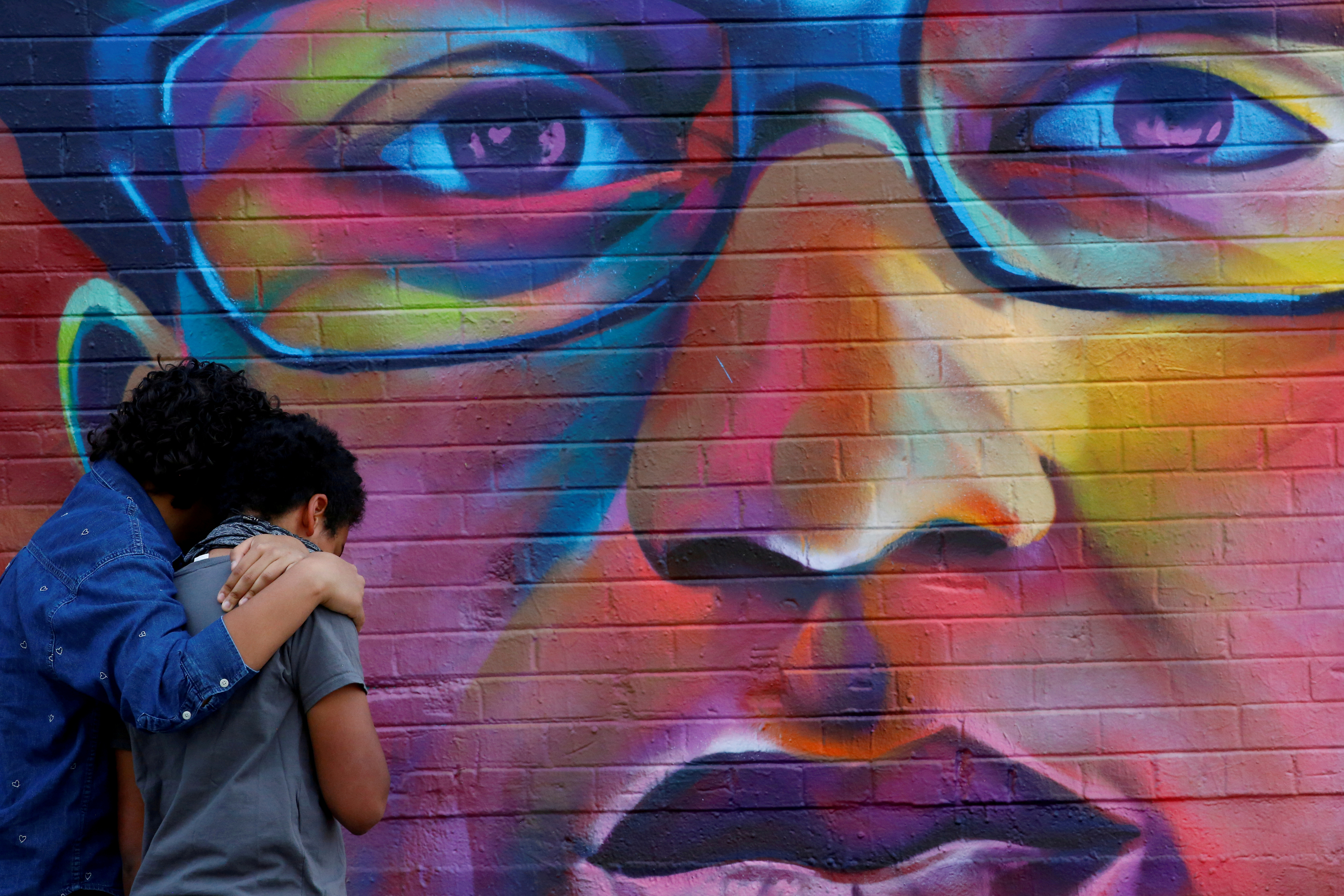 People visit a mural ahead of the one year anniversary of Elijah McClain's death