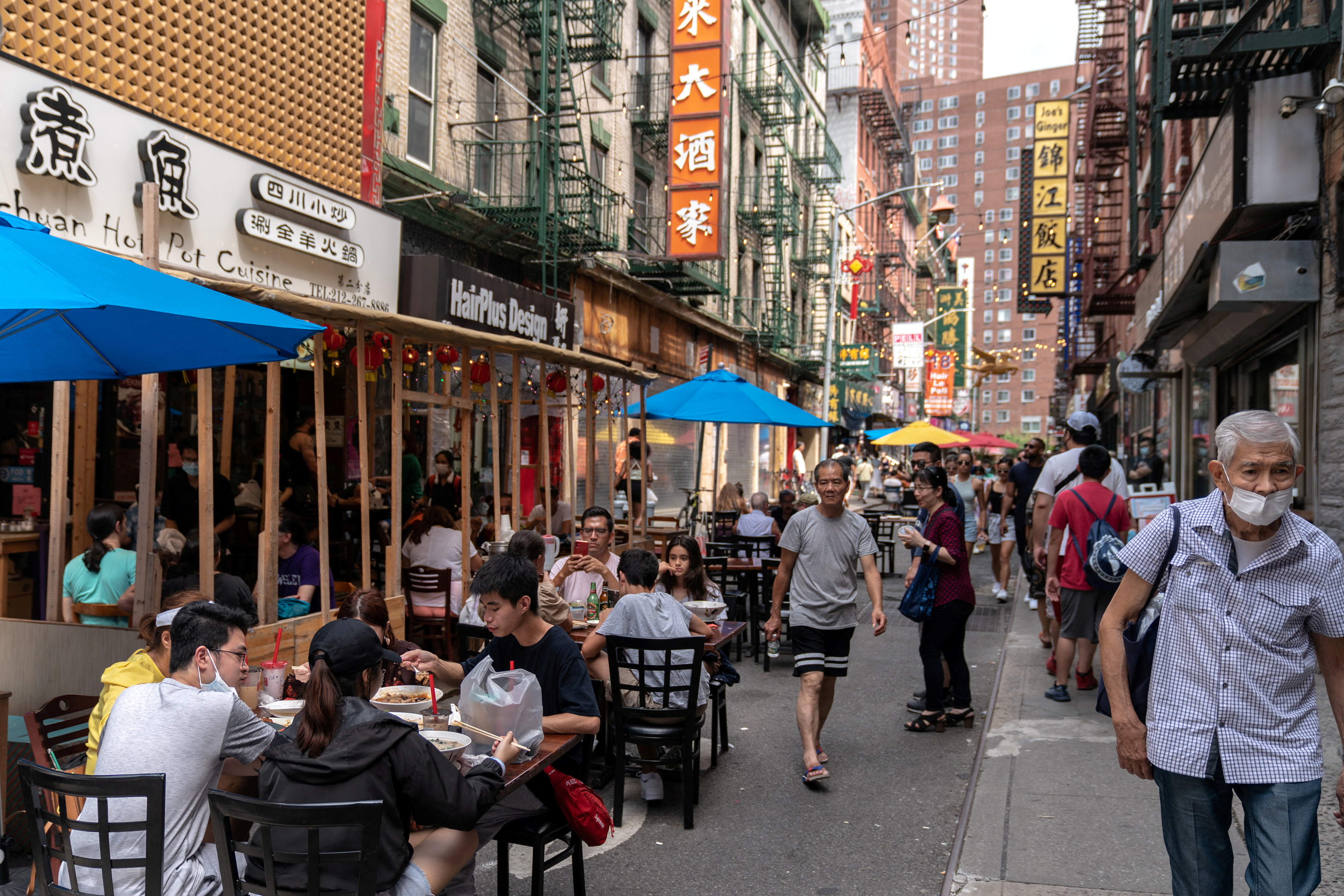 People sit in an outdoor dining area in Manhattan's Chinatown district in New York City