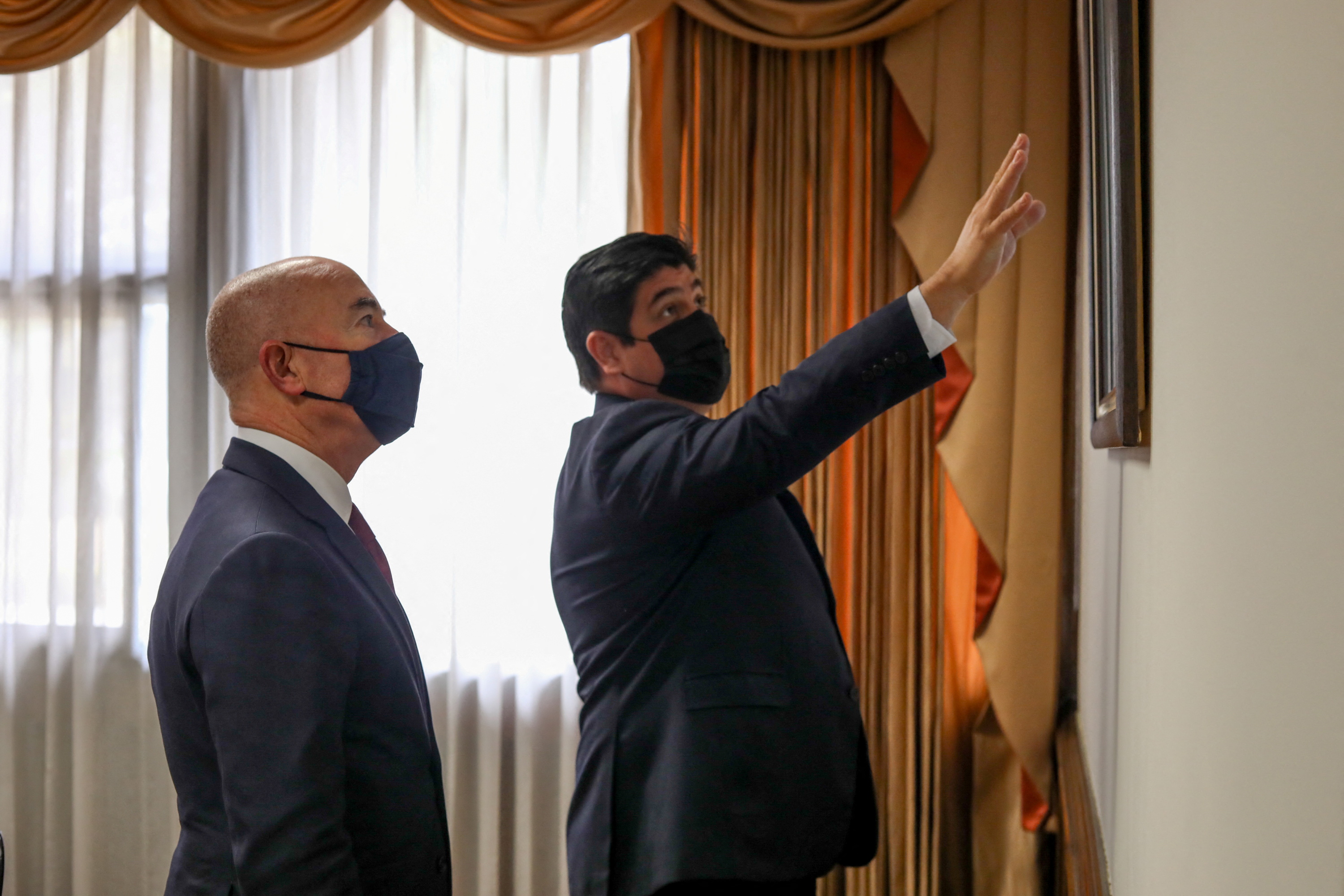 U.S. Homeland Security Secretary Alejandro Mayorkas looks on while Costa Rica's President Carlos Alvarado Quesada shows him a map after attendig a meeting in San Jose