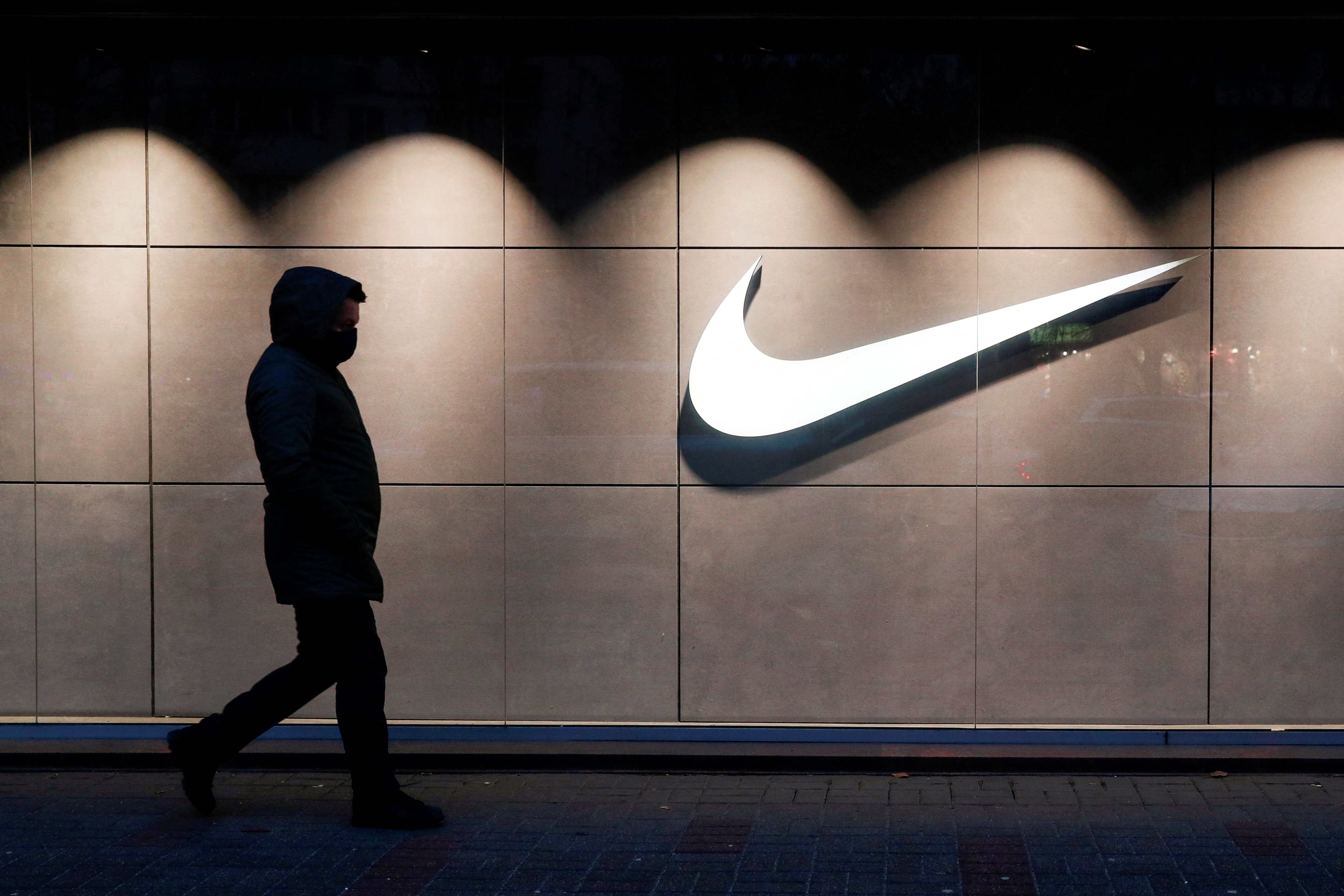 A man wearing a protective face mask walks past a Nike brand store central in Kyiv