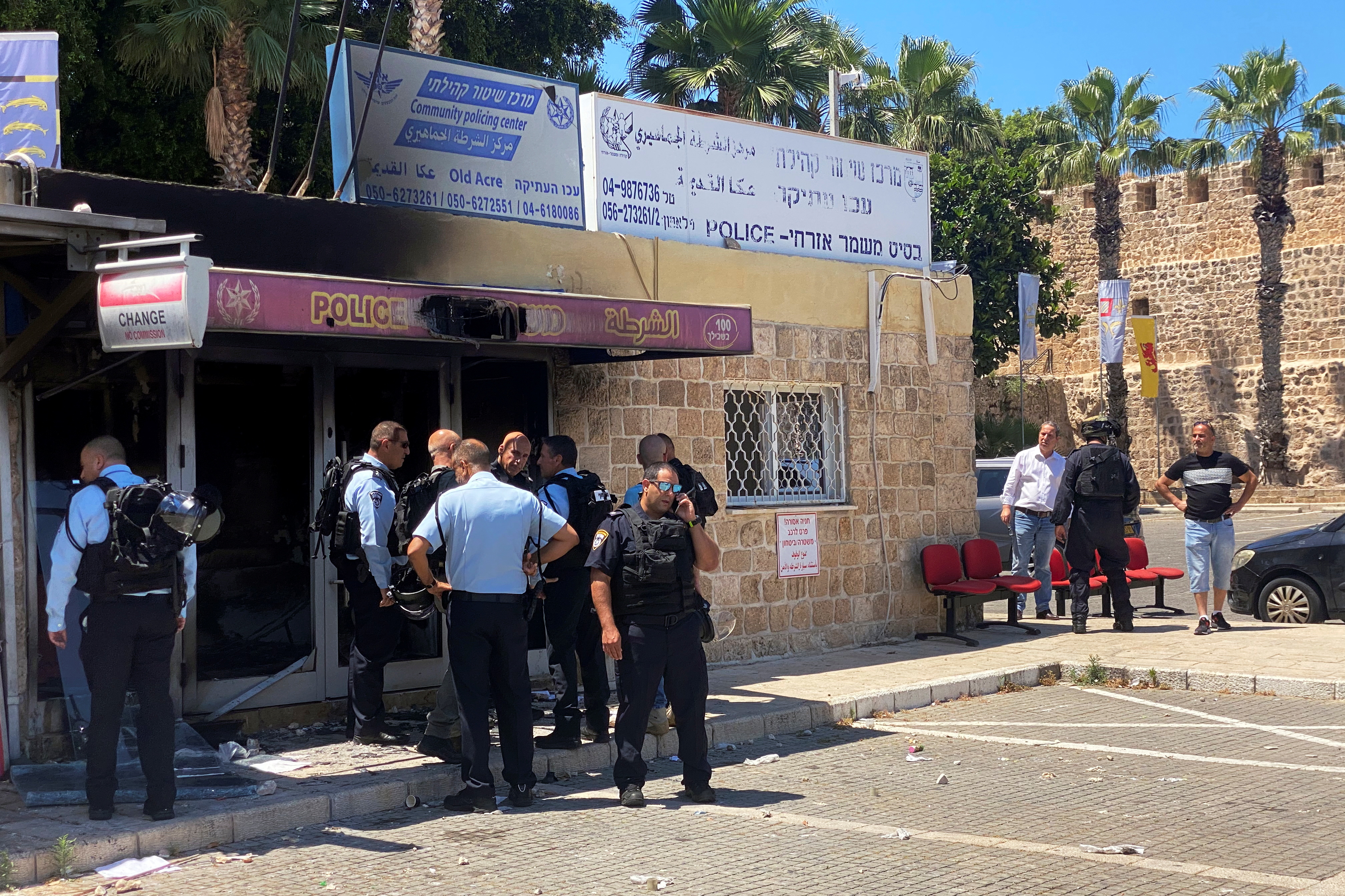 Israeli policemen gather as they inspect a partially torched police station in the Arab-Jewish mixed coastal city of Acre