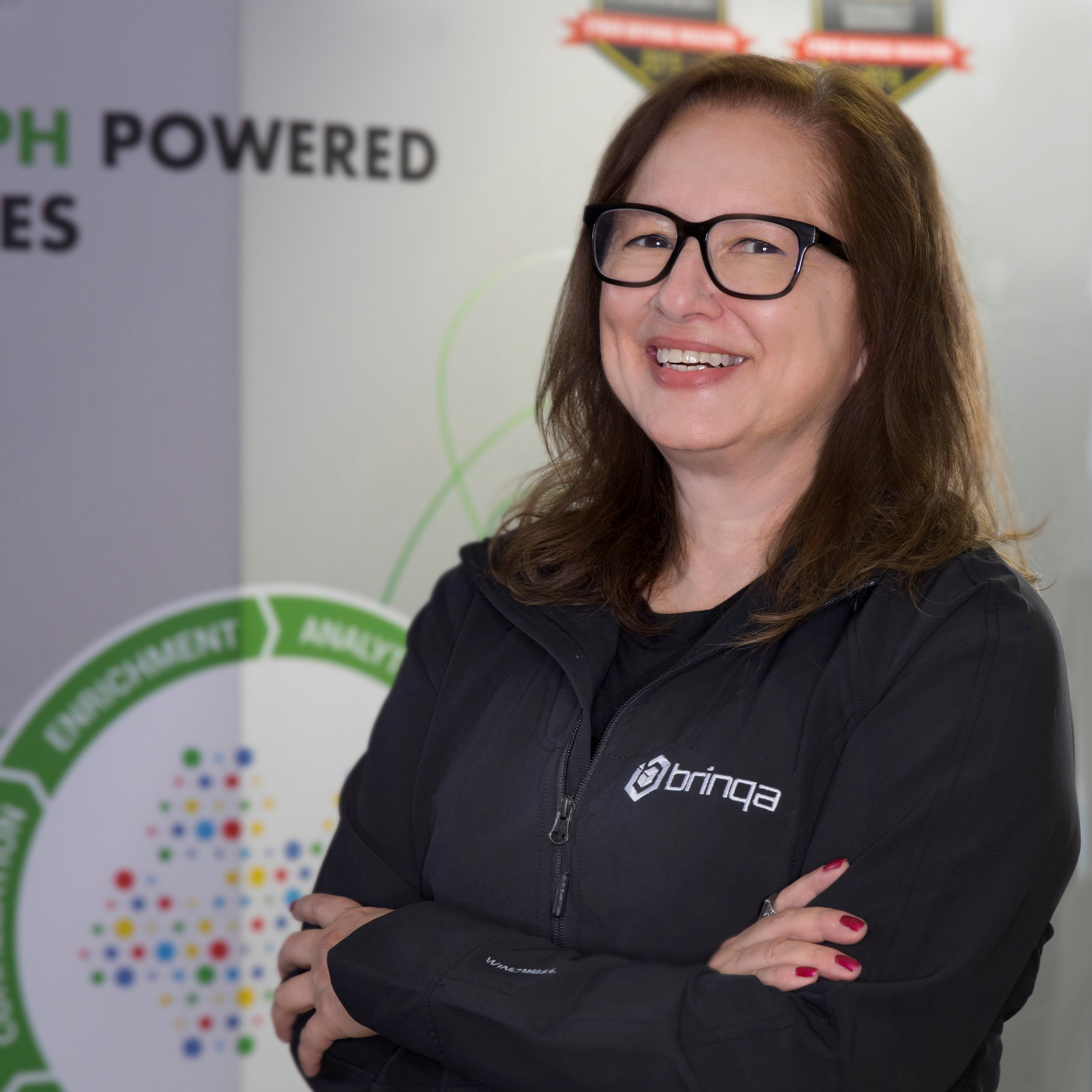 Co-founder and president of cybersecurity startup Brinqa Hilda Perez poses in a jacket with the company logo