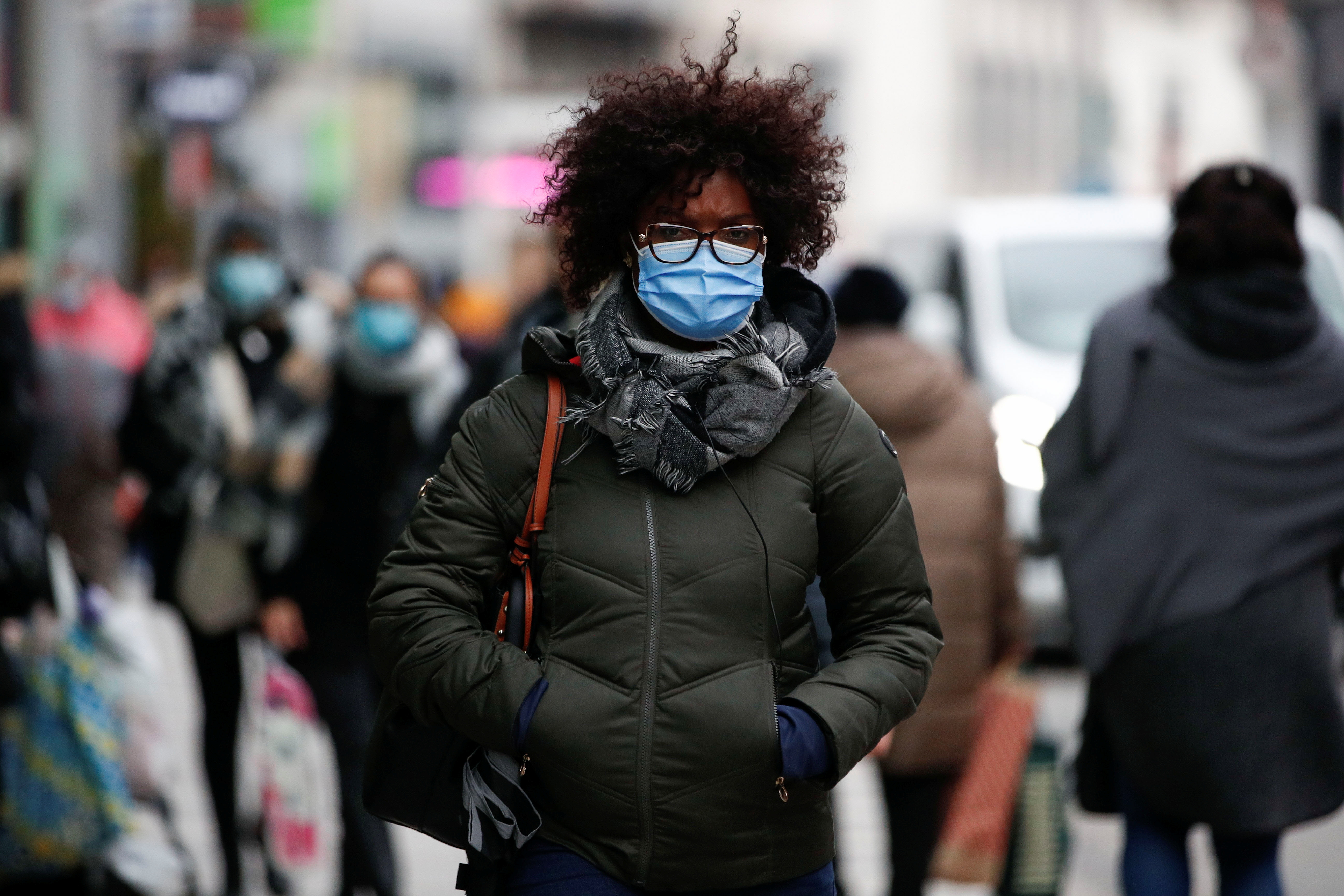 People wearing protective masks walk on a street, following the government's restrictions imposed to contain the spread of coronavirus disease (COVID-19) in Brussels