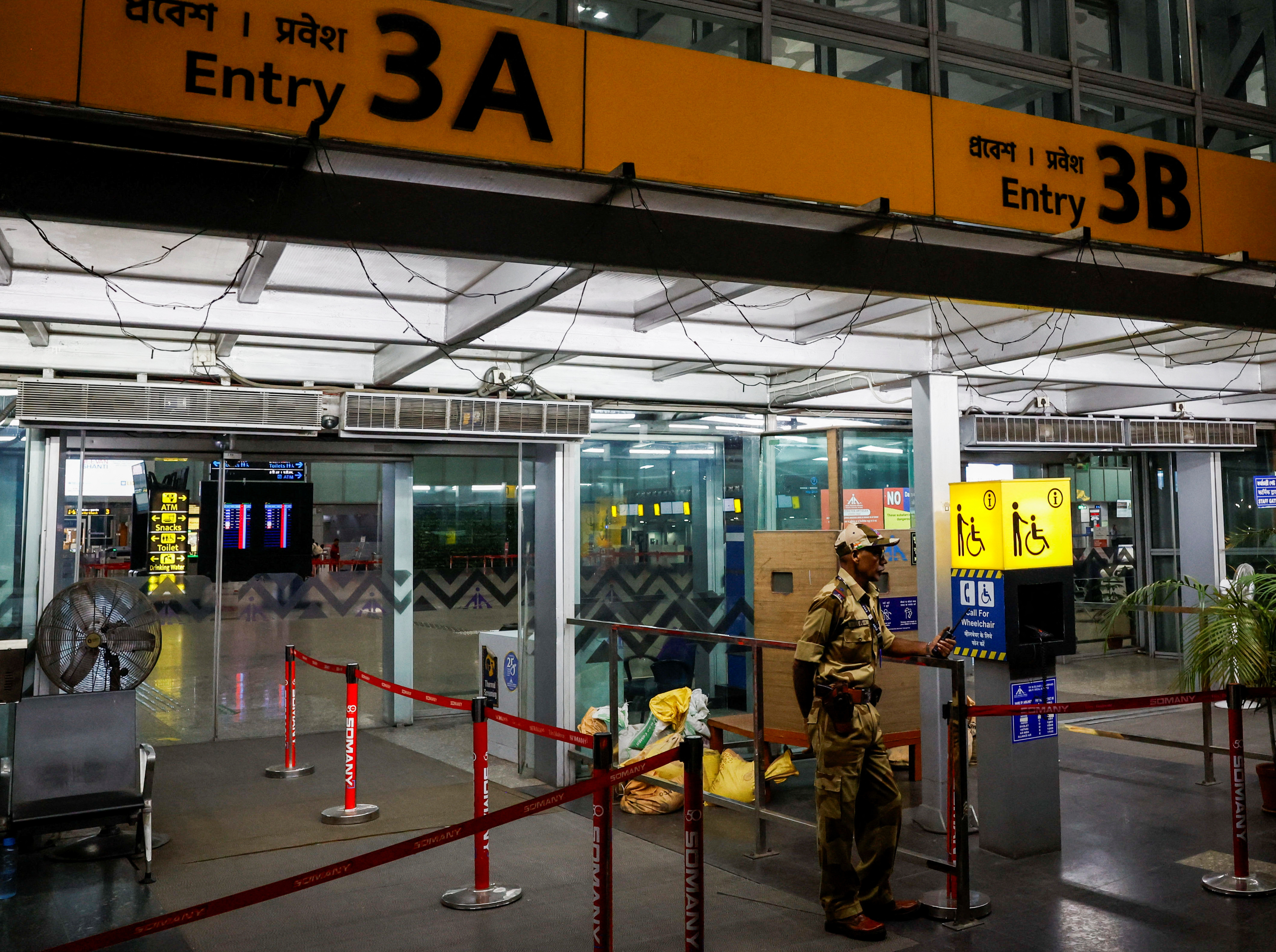 A Central Industrial Security Force (CISF) official stands outside the departure gates of Netaji Subhas Chandra Bose International Airport after flights were cancelled in preparations ahead of cyclone Dana in Kolkata