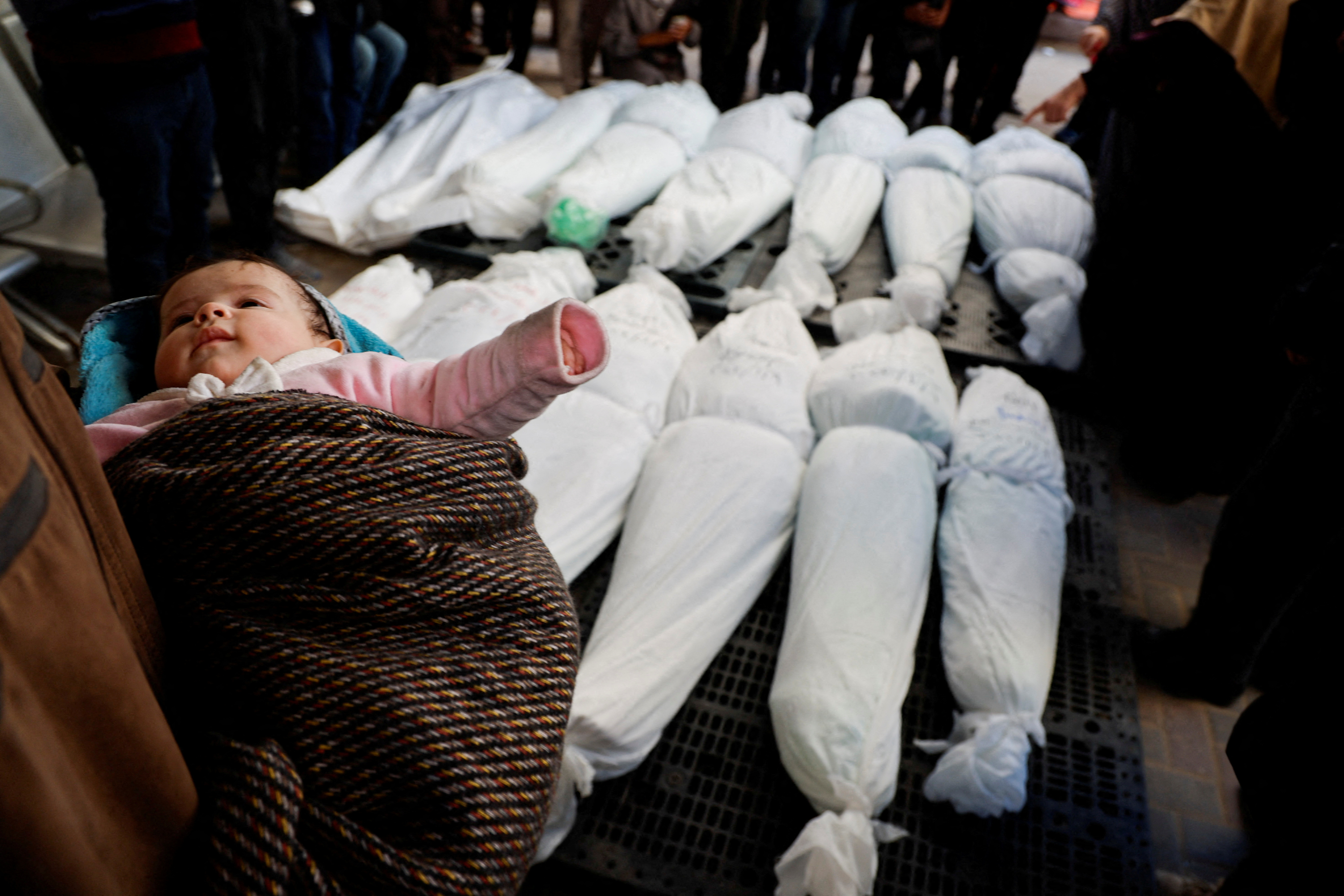 Mourners react next to the bodies of Palestinians killed in an Israeli strike, in Rafah