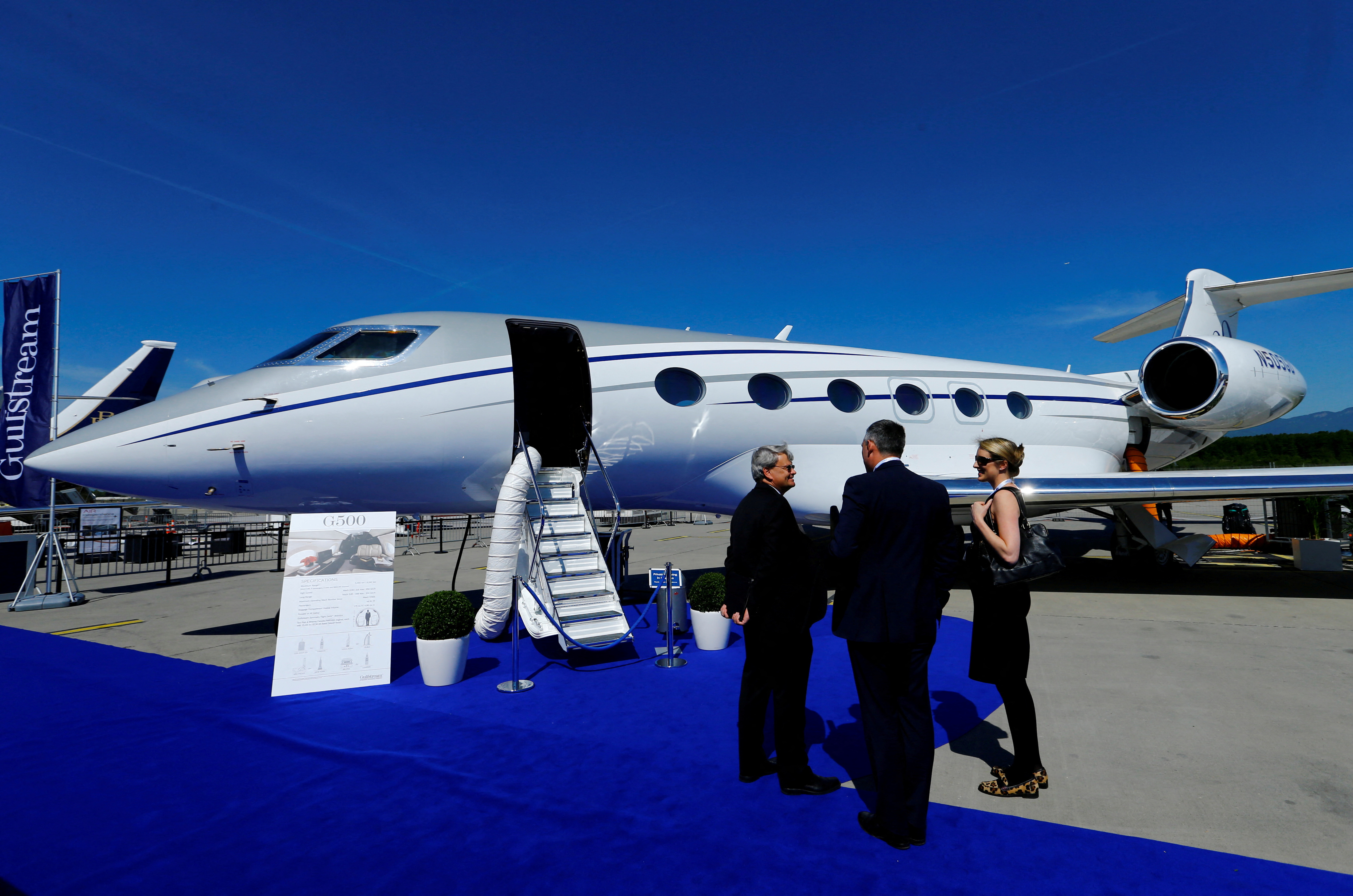 People stand in front of G500 Gulfstream aircraft during EBACE in Geneva