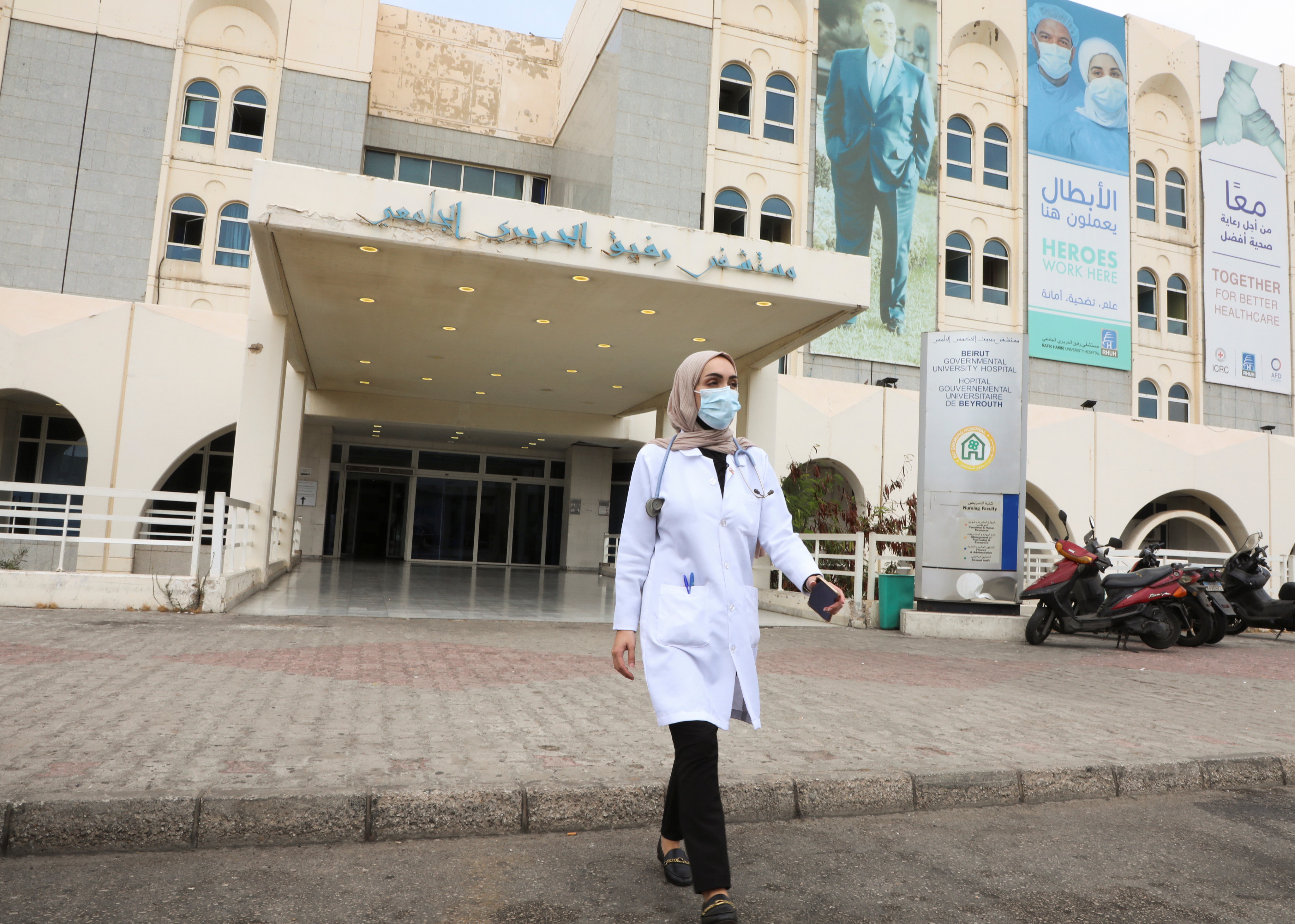 Israa Seblani, a Lebanese doctor and the bride who was caught up in the last year's Beirut port blast during a wedding photoshoot, walks outside Rafik Hariri University Hospital, in Beirut