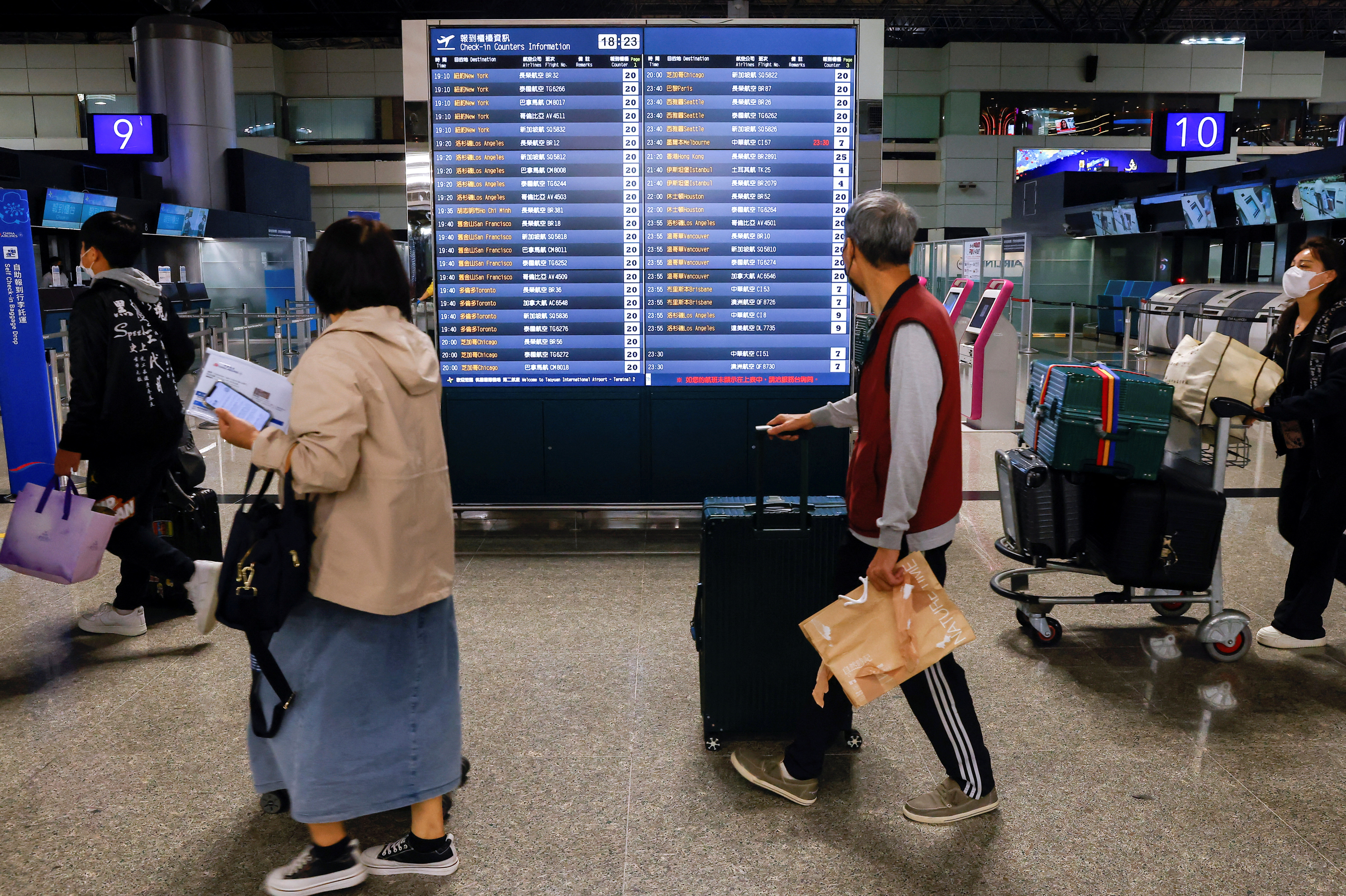 People look at flight information at Taiwan Taoyuan International Airport in Taoyuan,