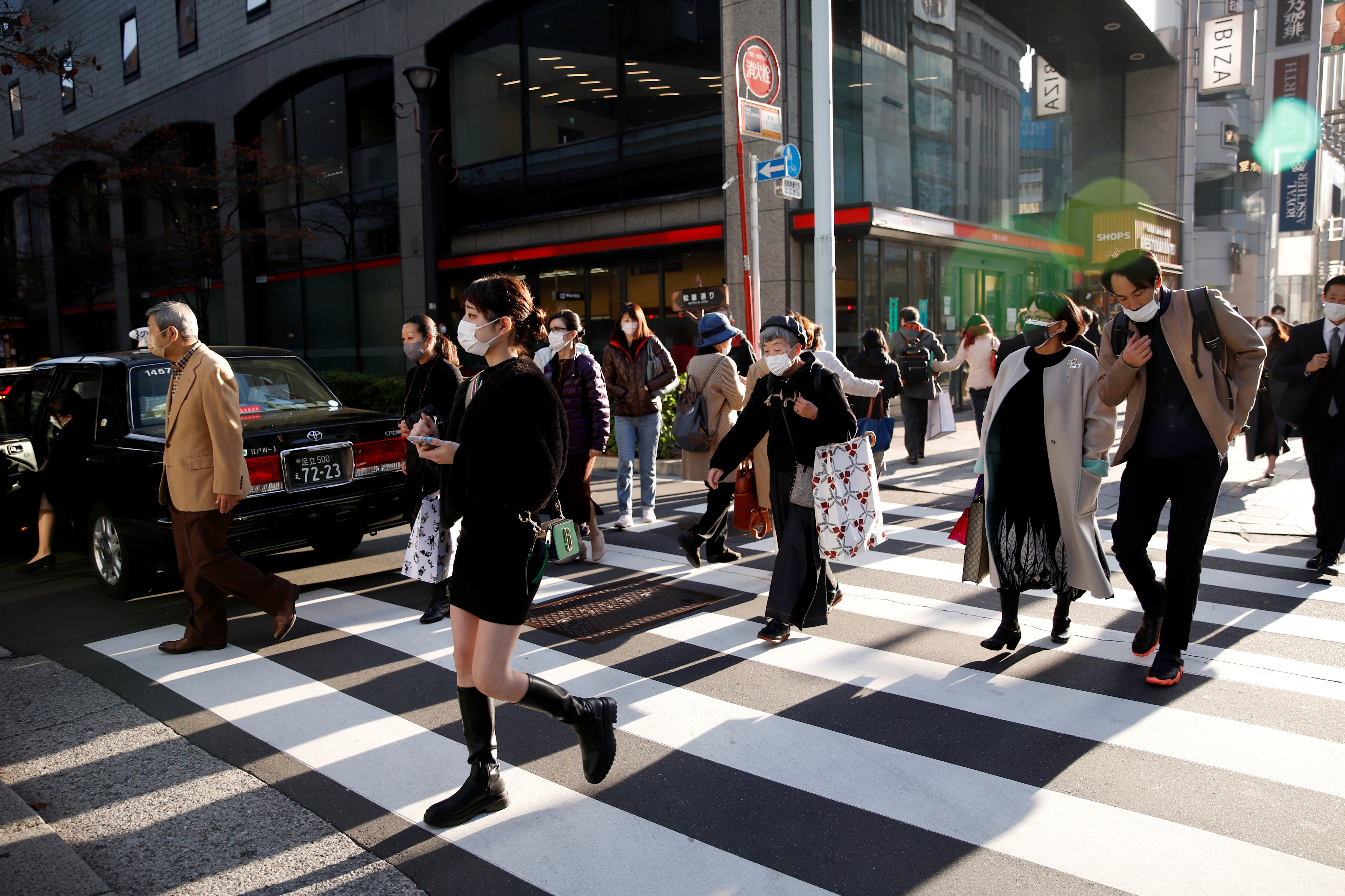 People cross the street in the Ginza shopping area, on the first day of Japan's closed borders to prevent the spread of the Omicron variant of coronavirus, in Tokyo.
