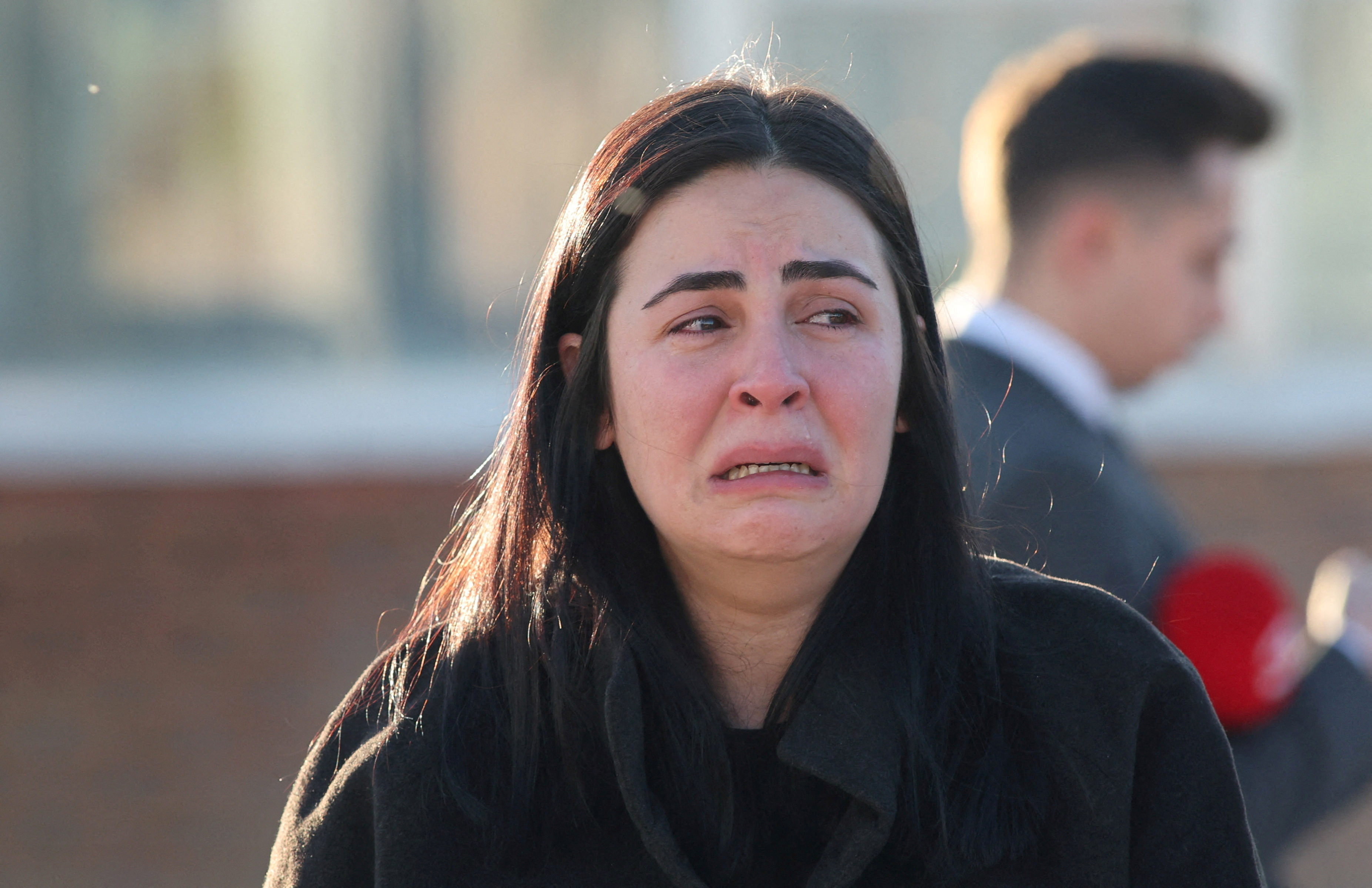 A woman reacts at the entrance of the headquarters of Turkey's aviation company TUSAS in Ankara