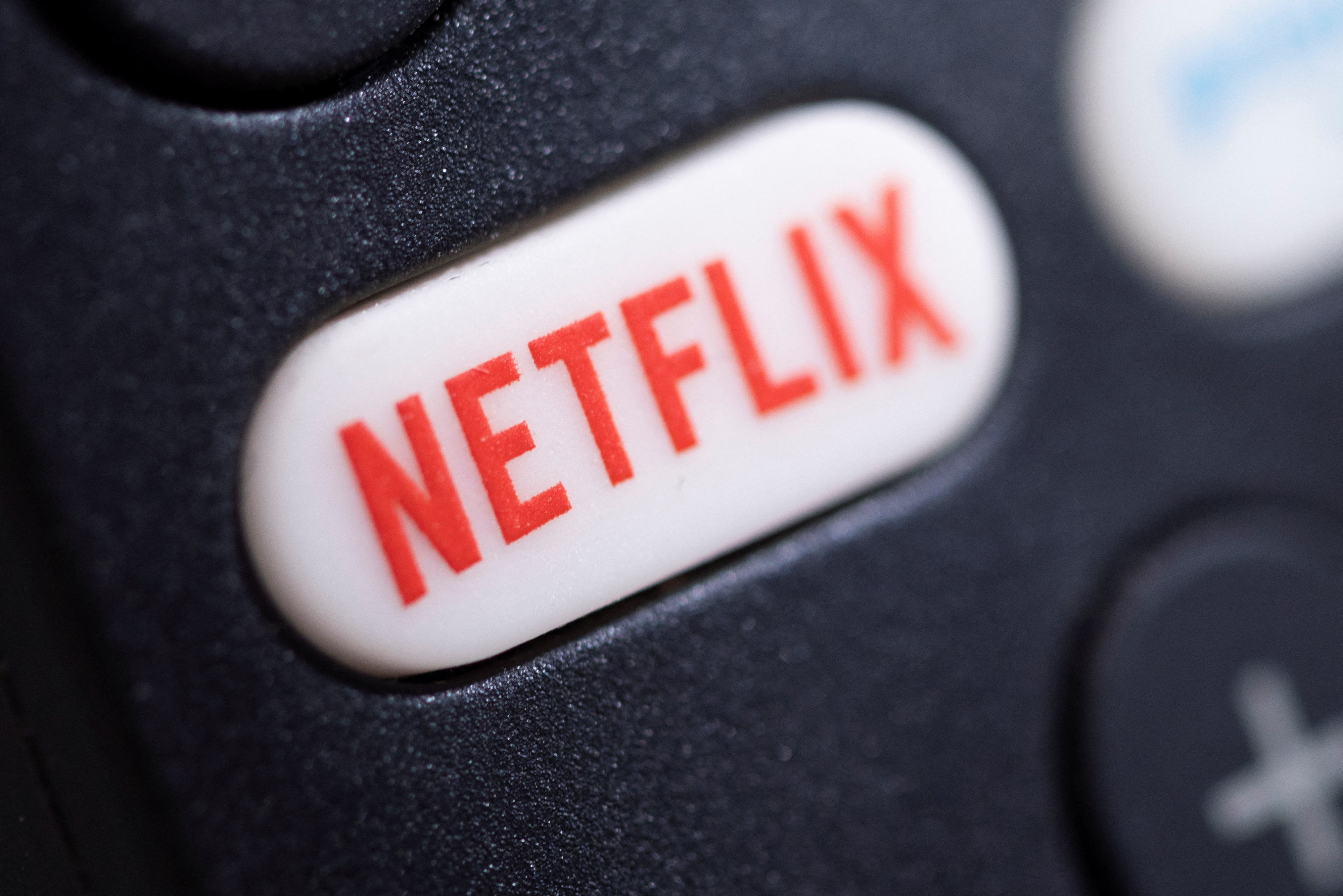 The Netflix logo is seen on a TV remote controller, in this illustration