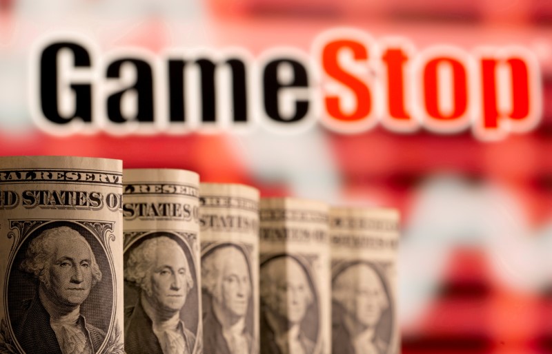 U.S. one dollar banknotes are seen in front of displayed GameStop logo