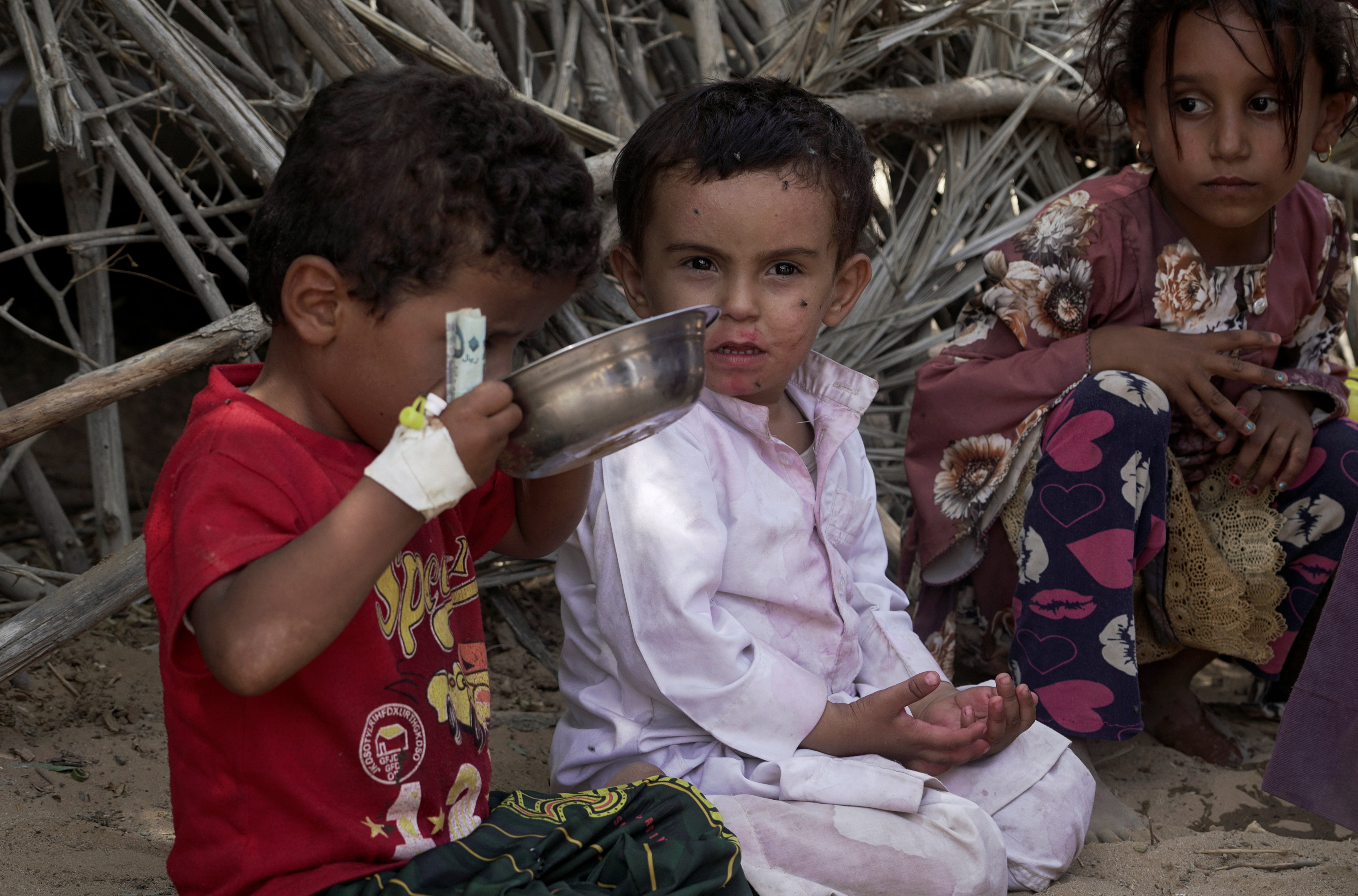 Children sit outside a hut at a camp for internally displaced people (IDPs) on the outskirts of Marib city, Yemen October 20, 2021. Picture taken October 20, 2021. REUTERS/Nabil al-Awzari/Files