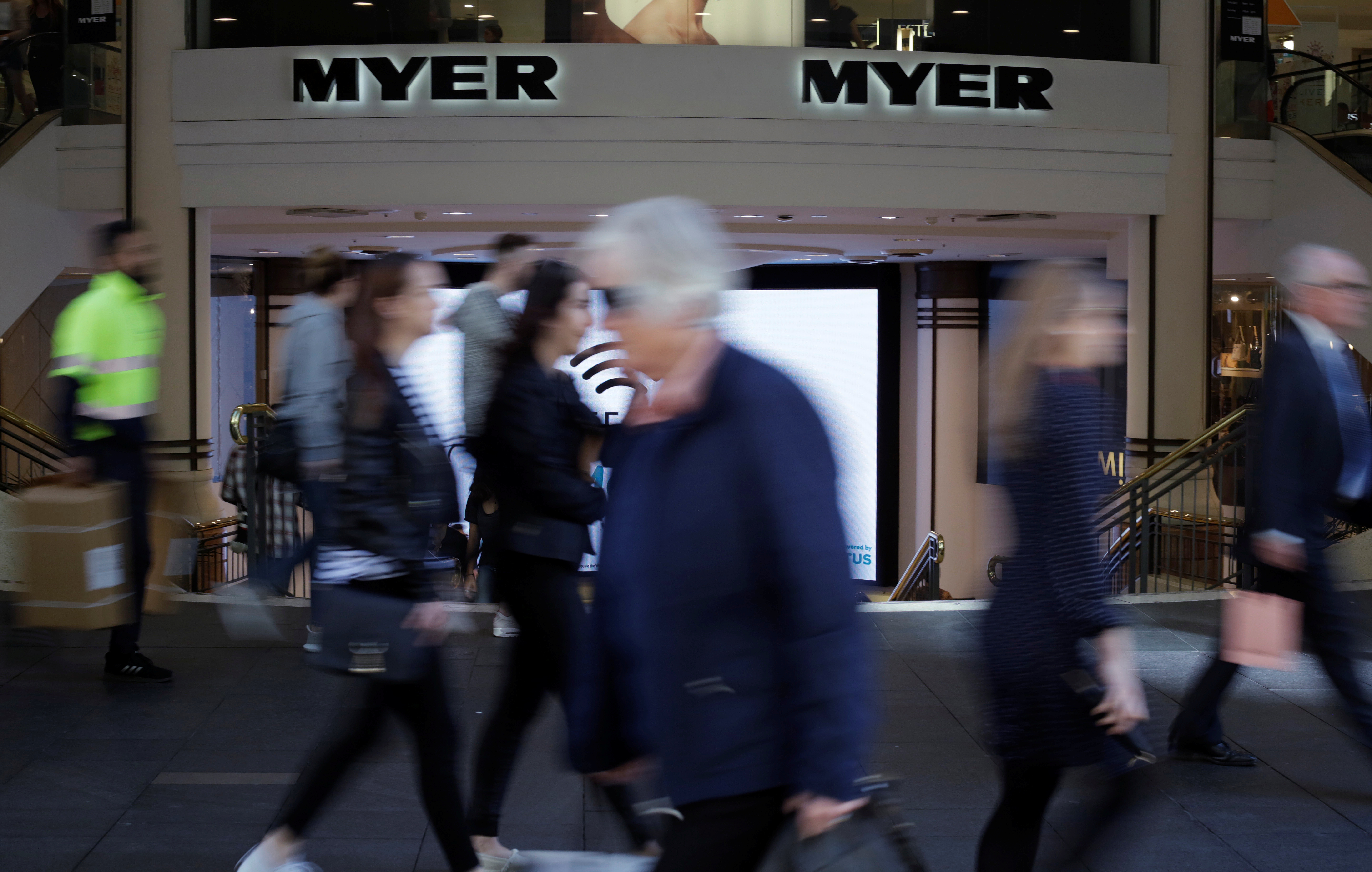 Shoppers walk outside a Myer department store, Australia's largest department store operator, in Sydney