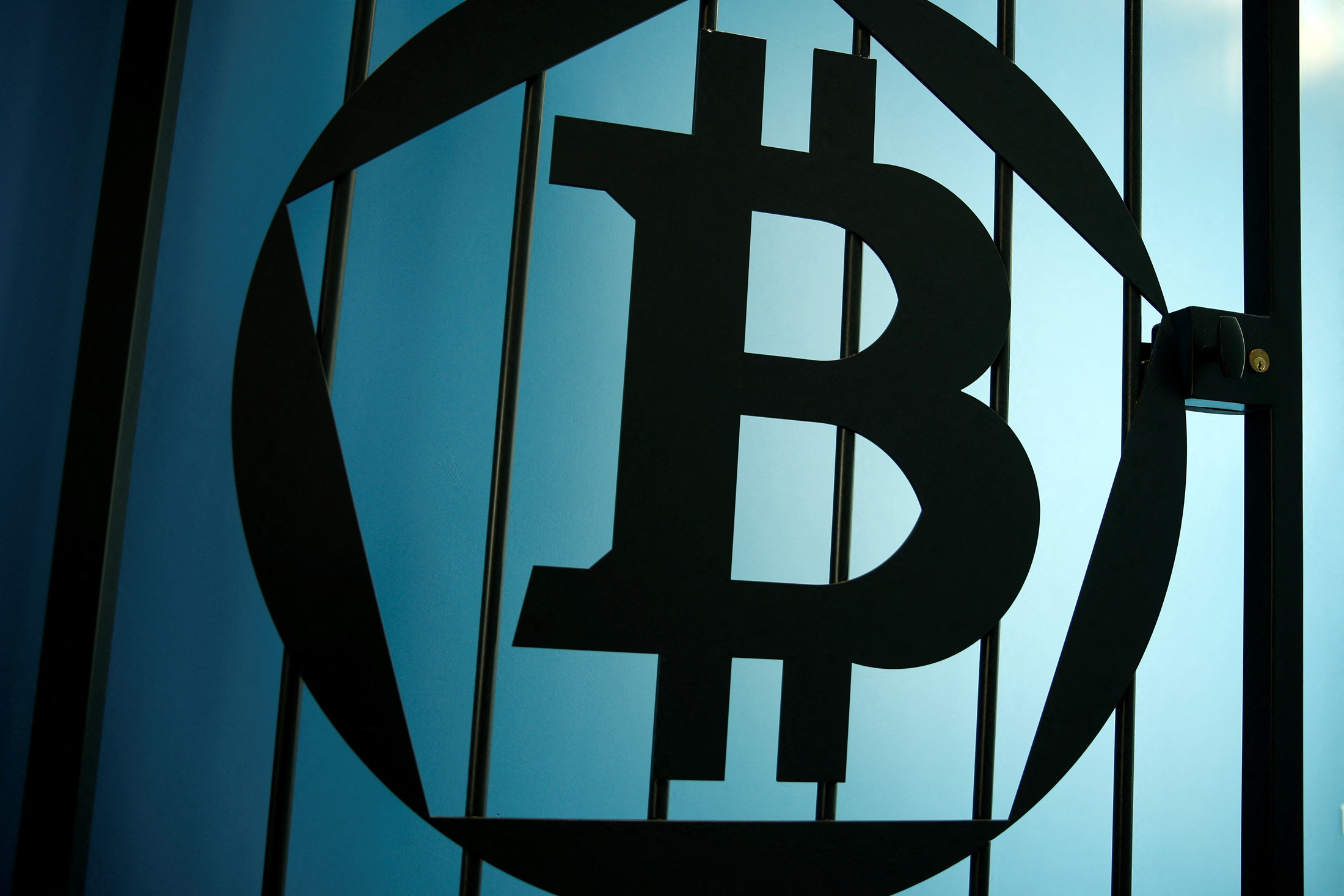 A bitcoin logo is pictured on a door at La Maison du Bitcoin in Paris
