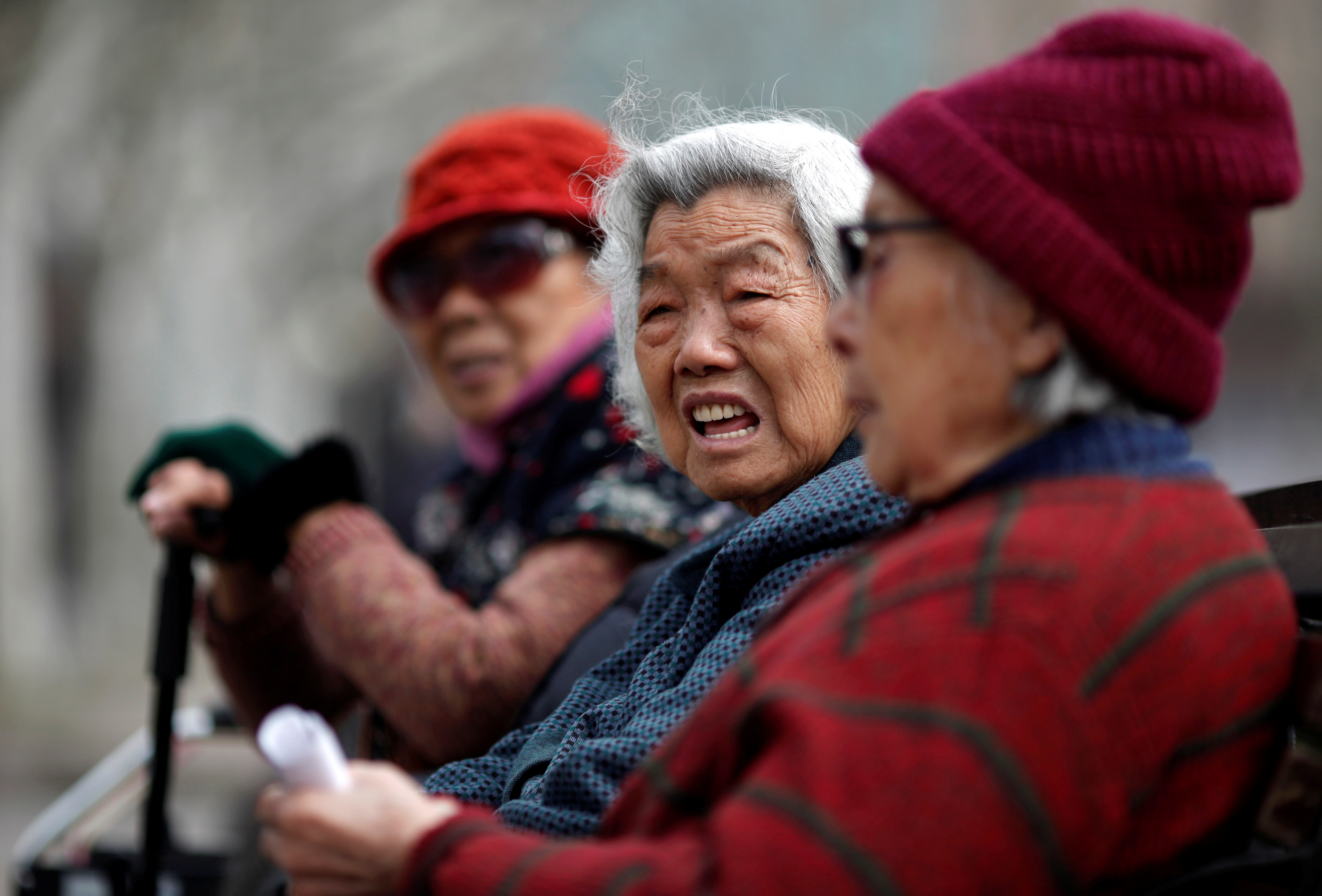 Elderly women sit at a park in downtown Shanghai