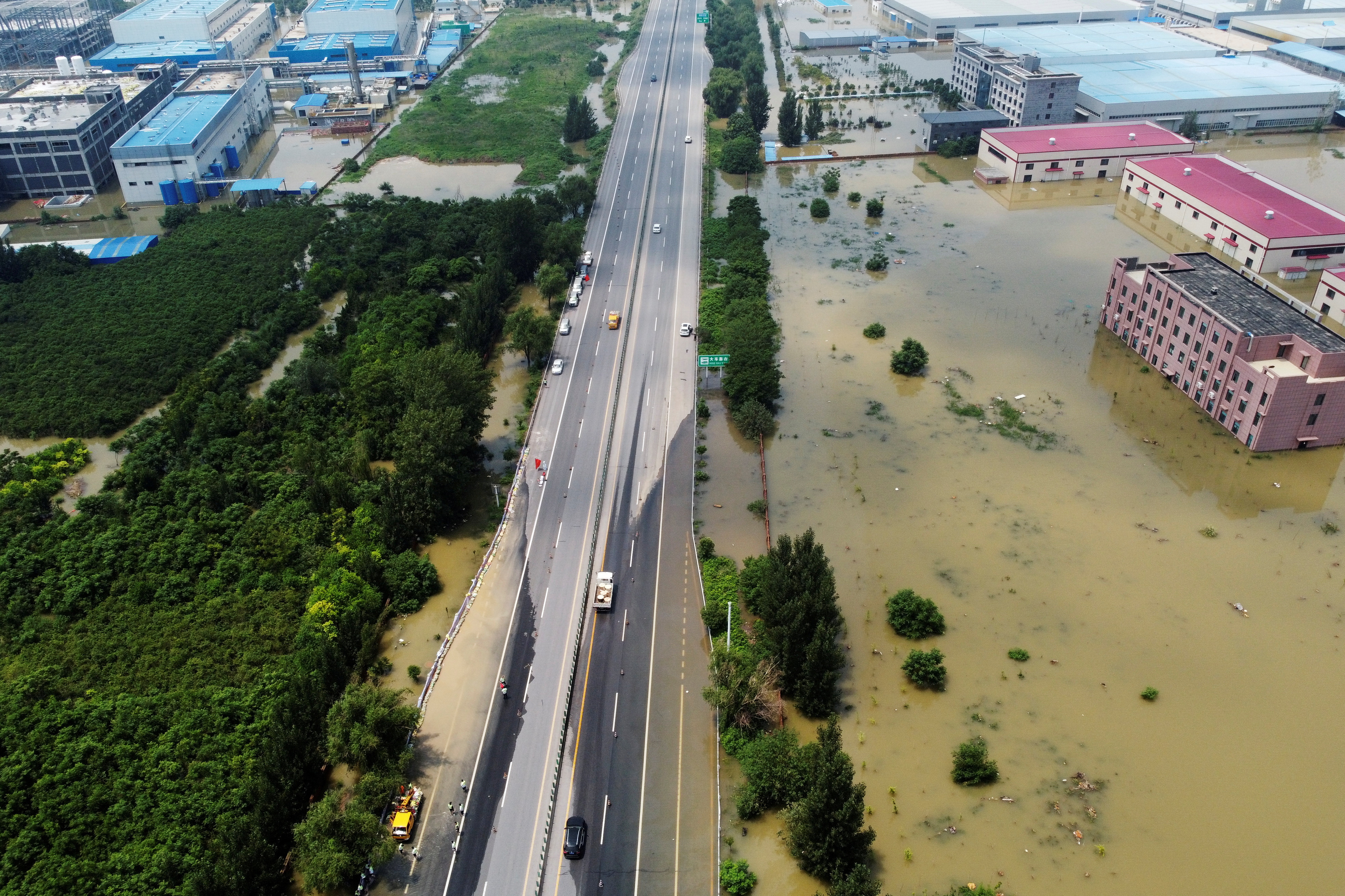 Aerial view shows flooded industrial buildings by a highway following heavy rainfall in Xinxiang