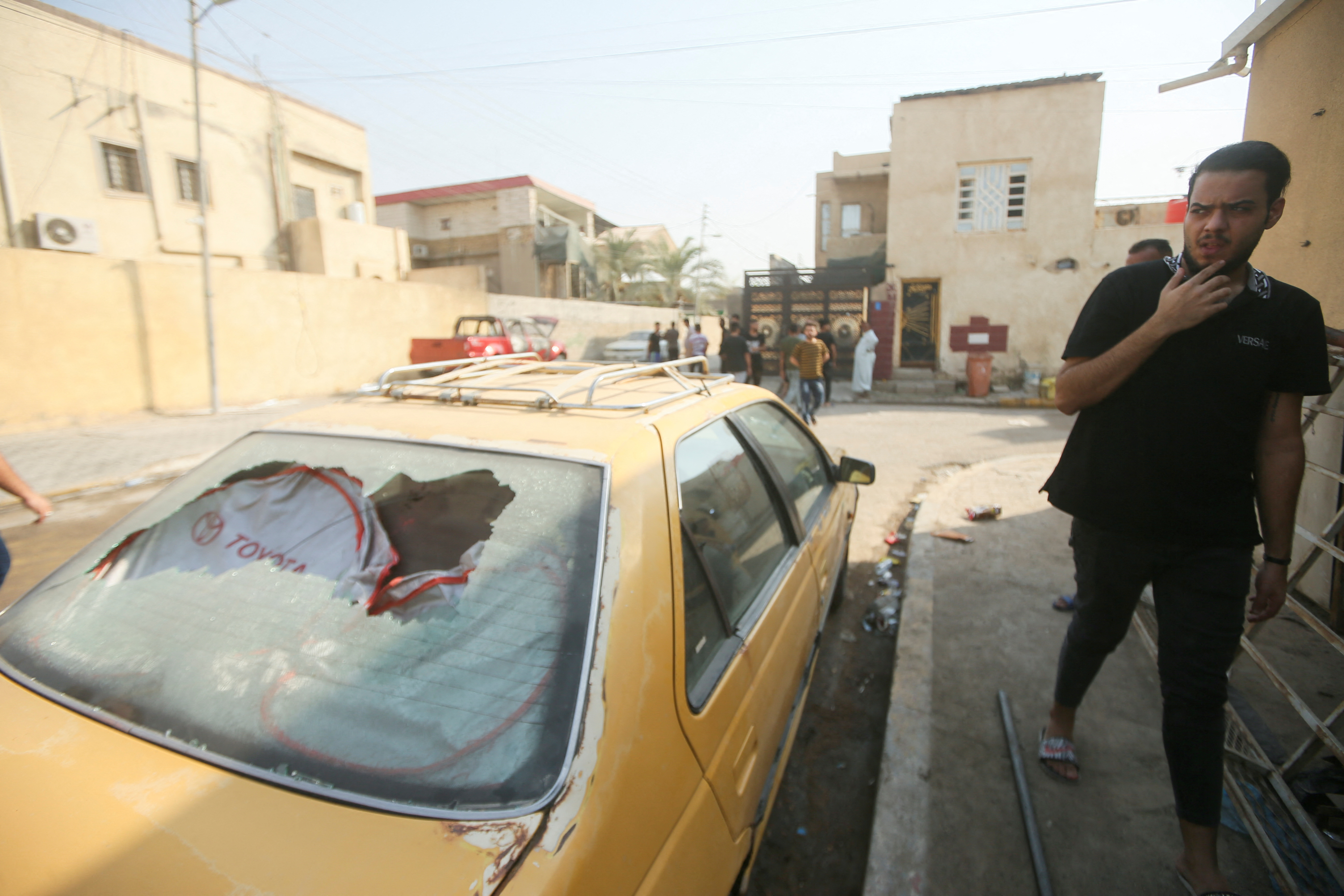 A man walks past a damaged vehicle on a street aftermath of clashes among rival Shiite Muslim militants in Basra