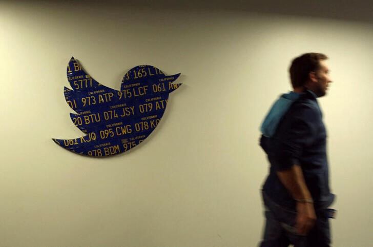 An employee walks past a Twitter logo made from Californian license plates at the company's headquarters in San Francisco