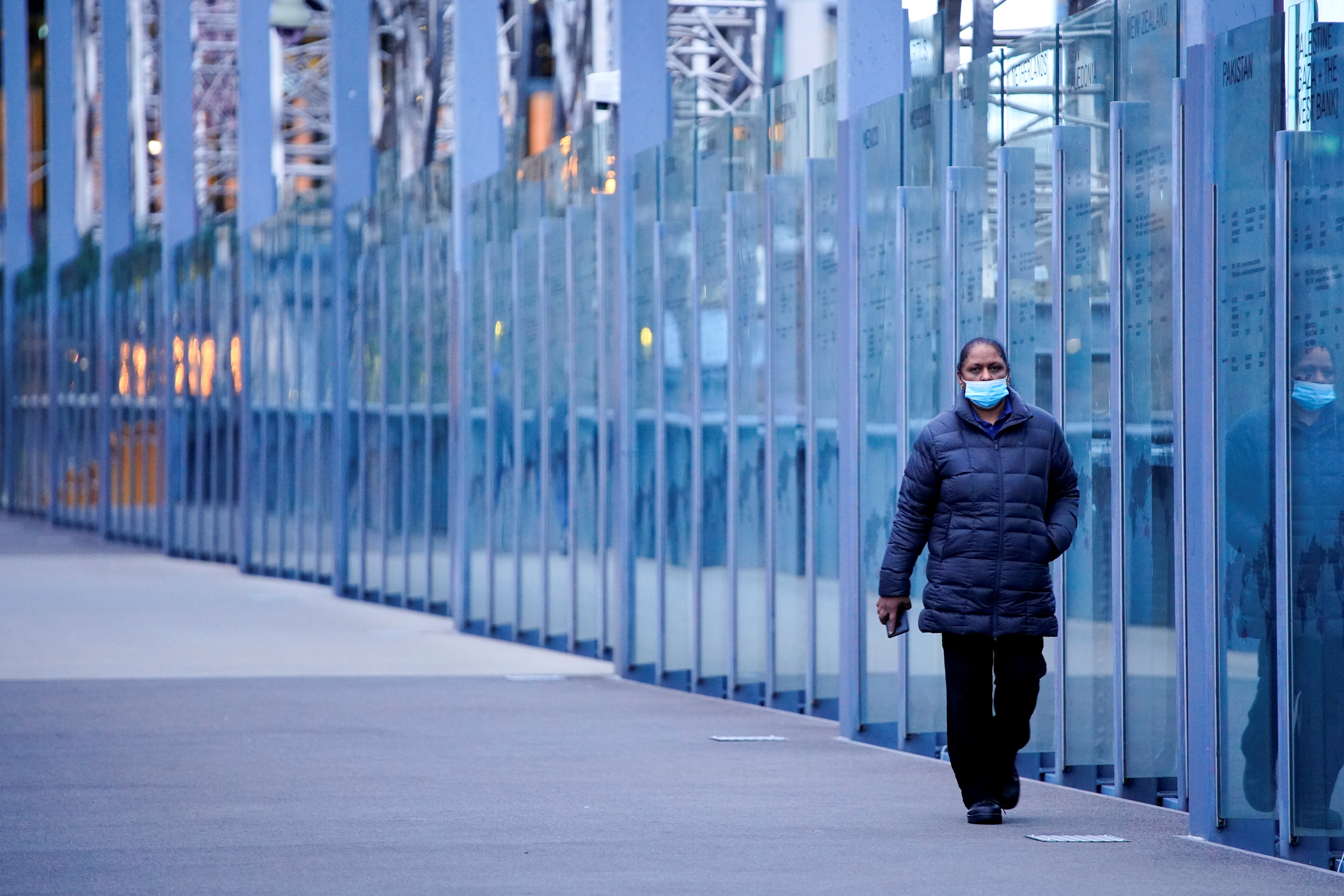 A woman walks along a city bridge a COVID-19 lockdown in Melbourne