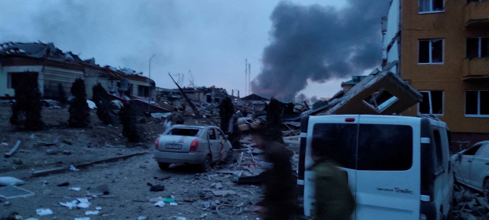 Smoke rises amid damaged buildings and vehicles following an attack on the Yavoriv military base, as Russia's invasion of Ukraine continues, in Yavoriv