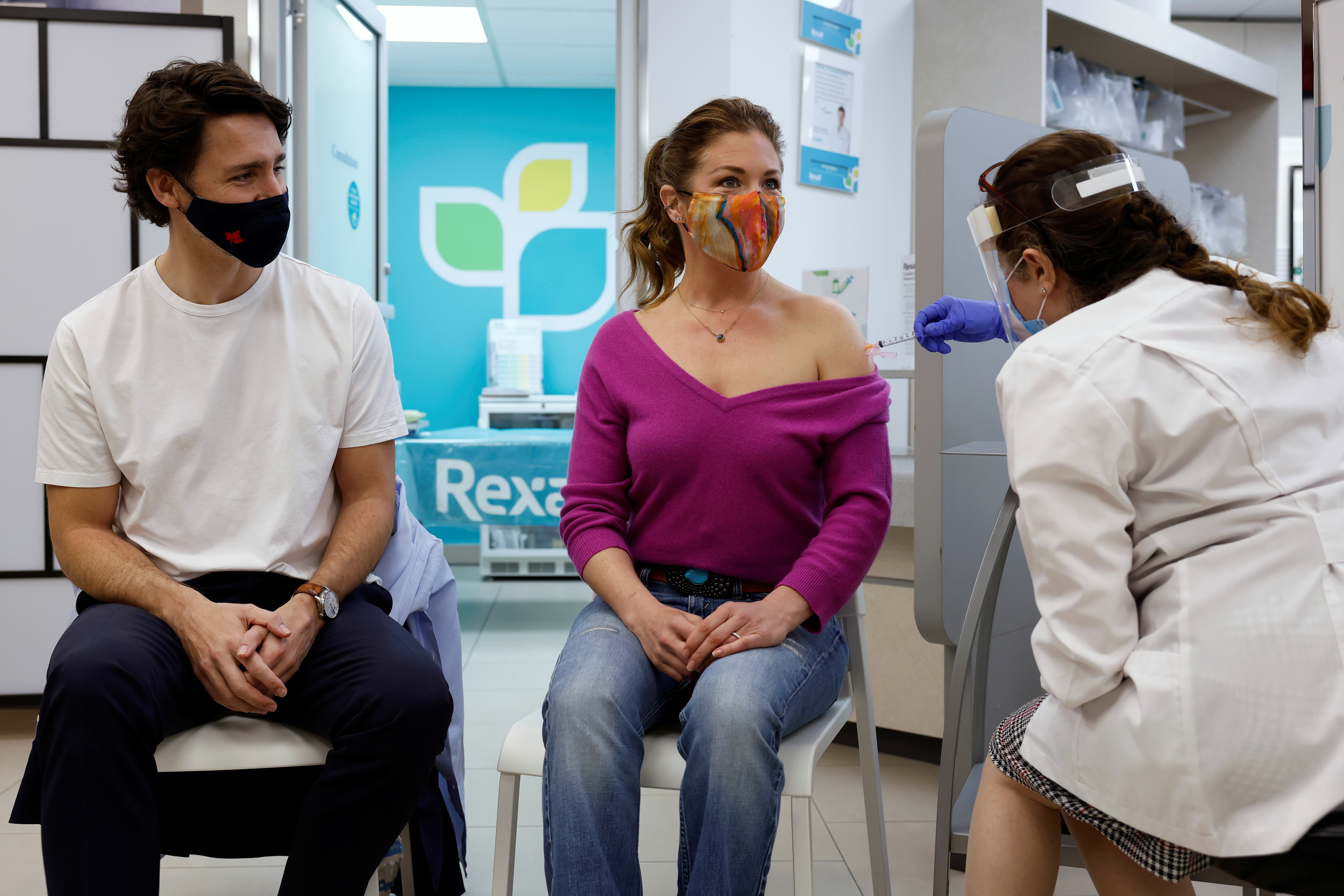 Canada's Prime Minister Justin Trudeau watches as his wife Sophie Gregoire is inoculated with AstraZeneca's vaccine against coronavirus disease (COVID-19) at a pharmacy in Ottawa, Ontario, Canada April 23, 2021.   REUTERS/Blair Gable