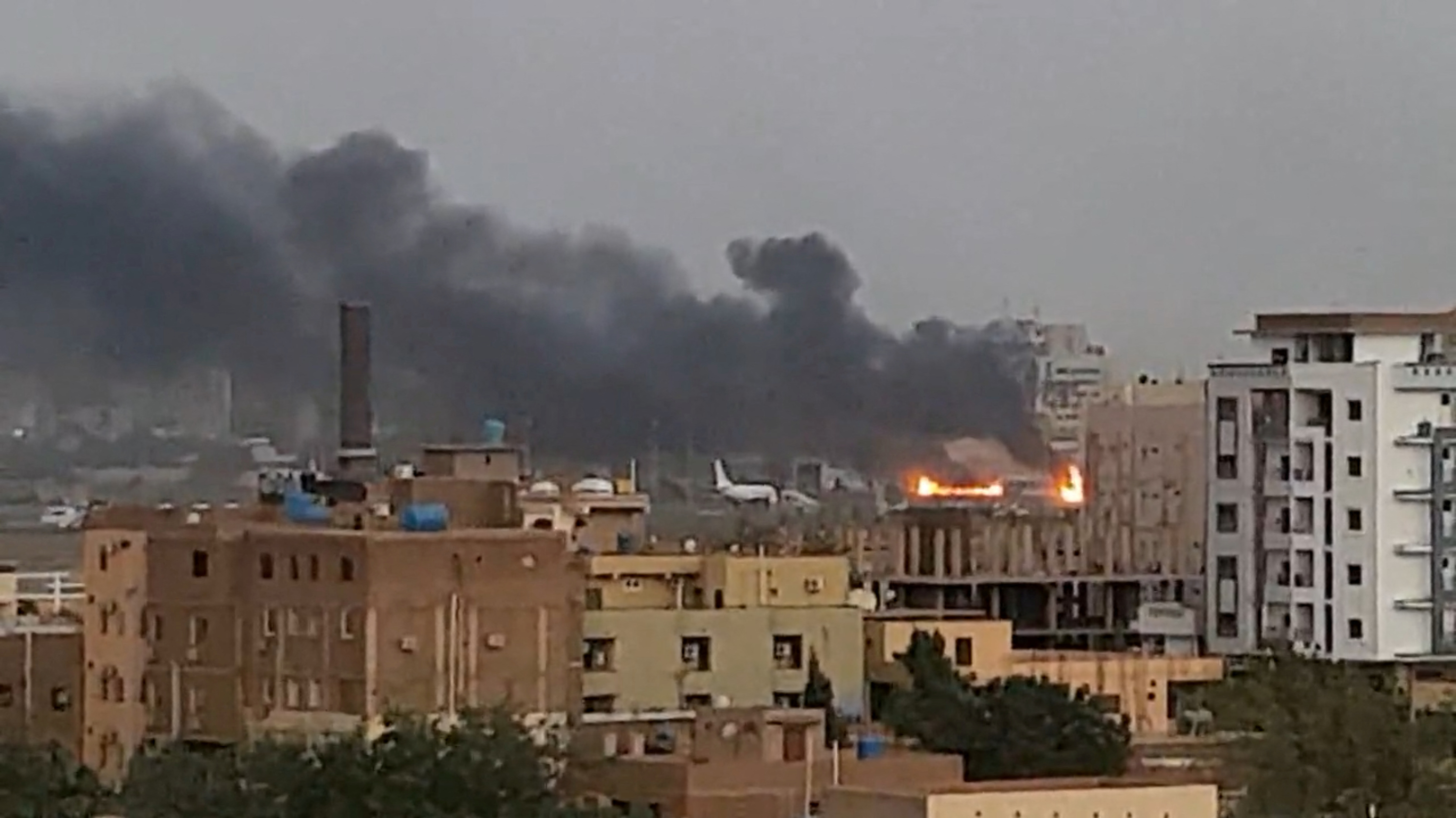 Smoke rises from the tarmac of Khartoum International Airport as a fire burns, in Khartoum