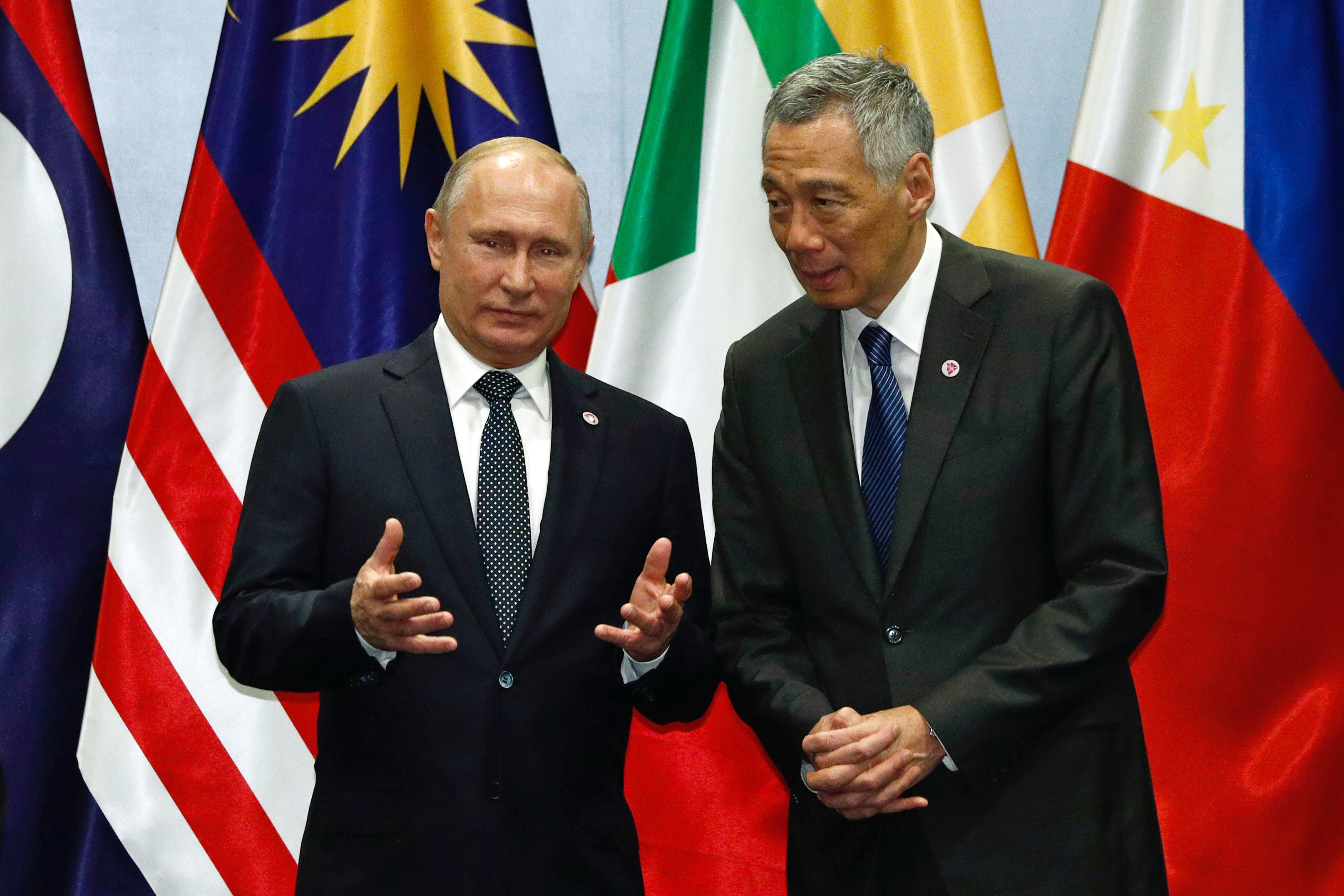 Russian President Vladimir Putin speaks with Singapore's Prime Minister Lee Hsien Loong during a group photo at the ASEAN-Russia Summit in Singapore