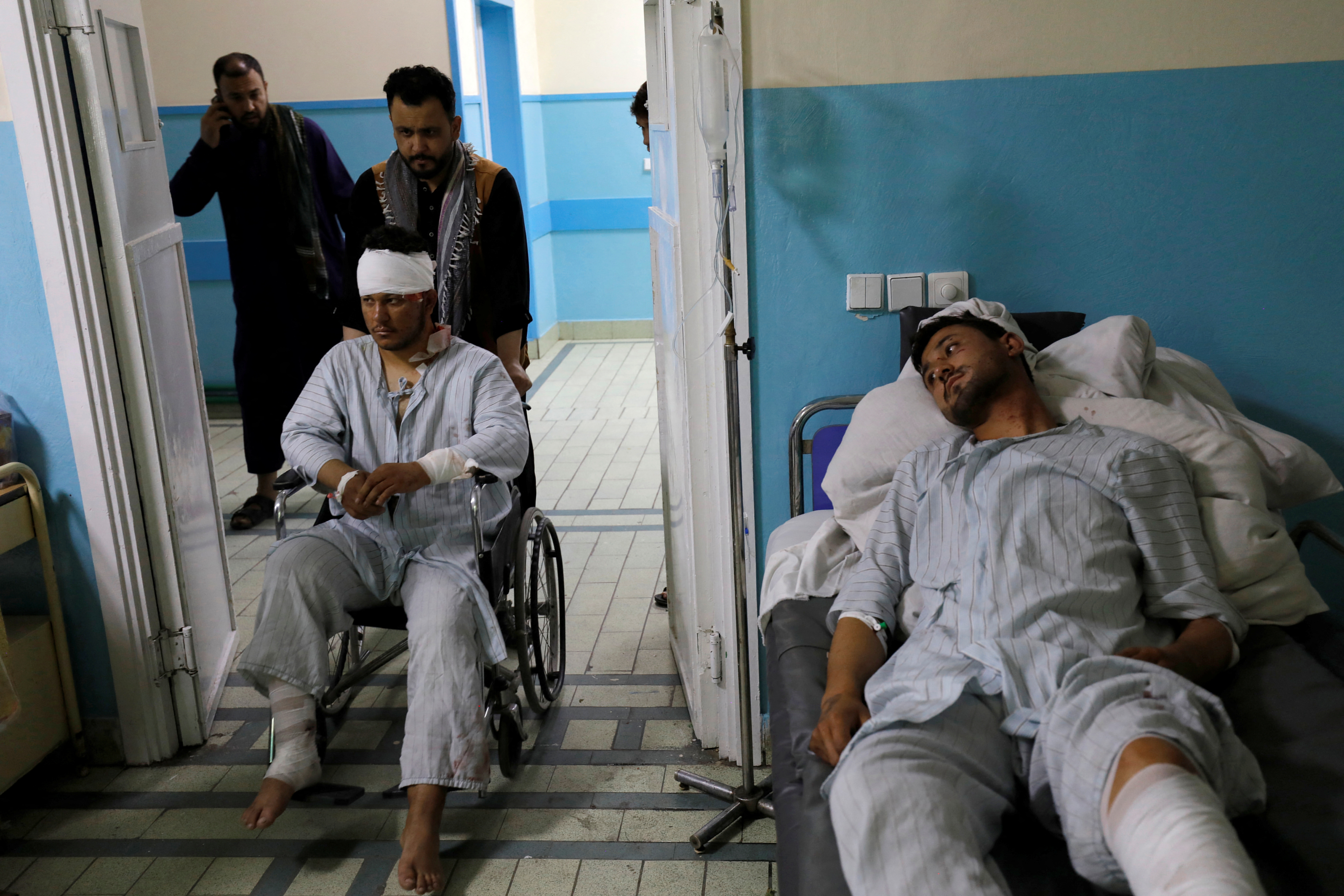 Wounded men are treated inside a hospital in Kabul