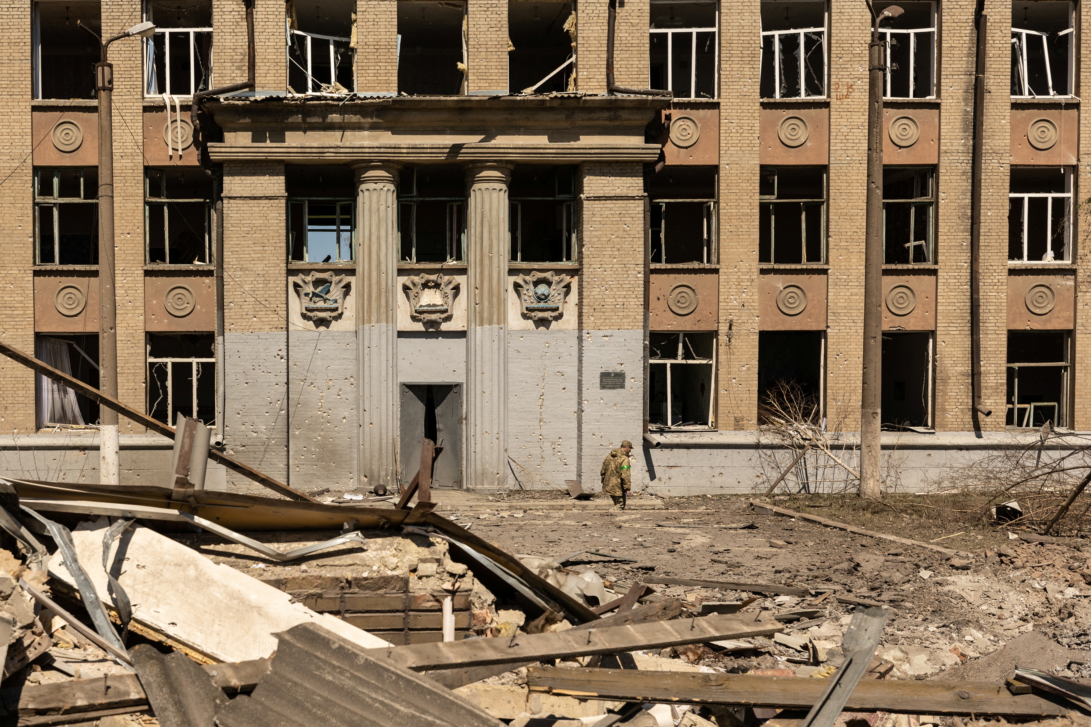 A Ukrainian soldier walks in front of a school that was bombed amid Russia's invasion in Ukraine, in Kostyantynivka, in the Donetsk region