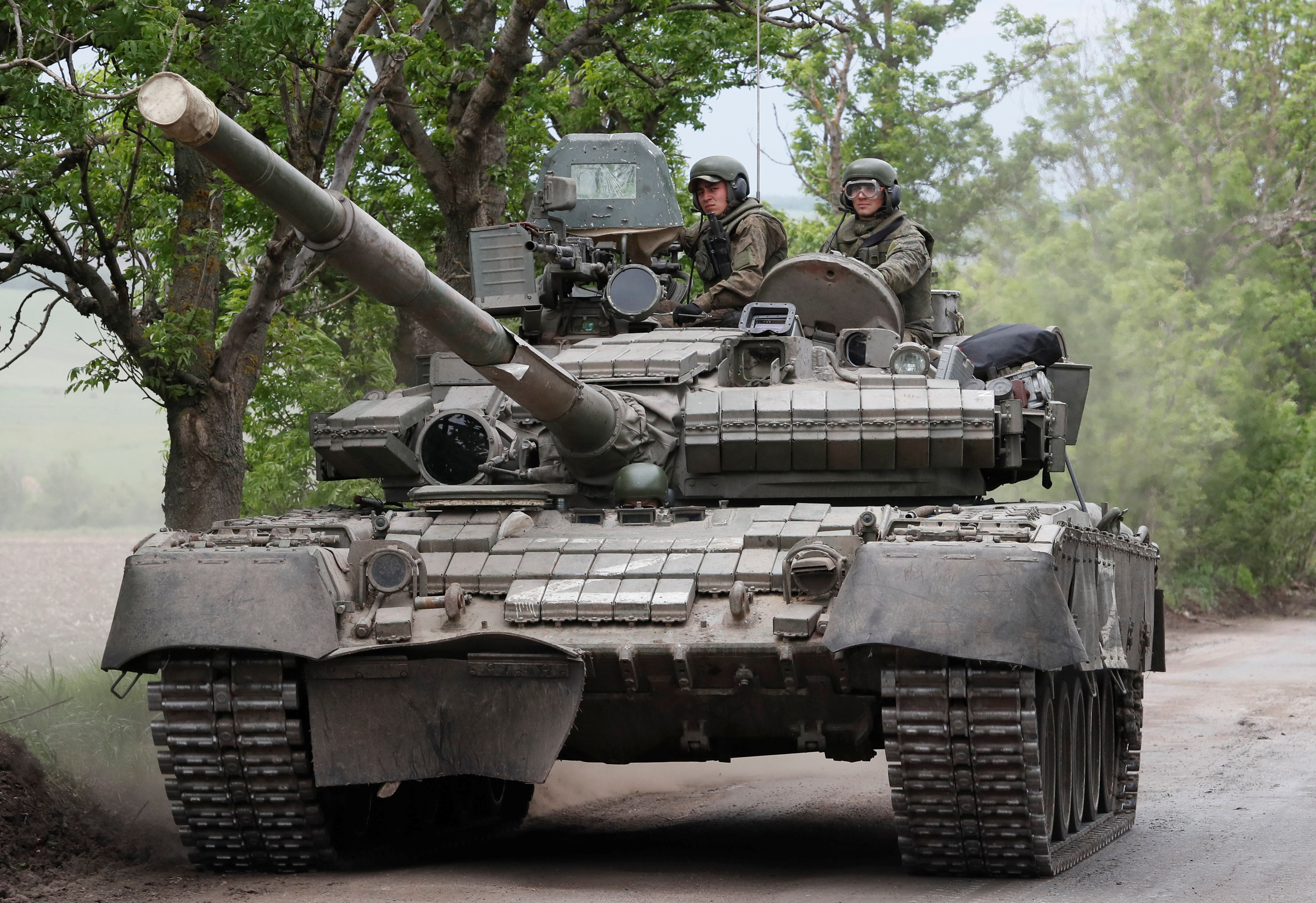 Service members of pro-Russian troops drive a tank in the Donetsk Region
