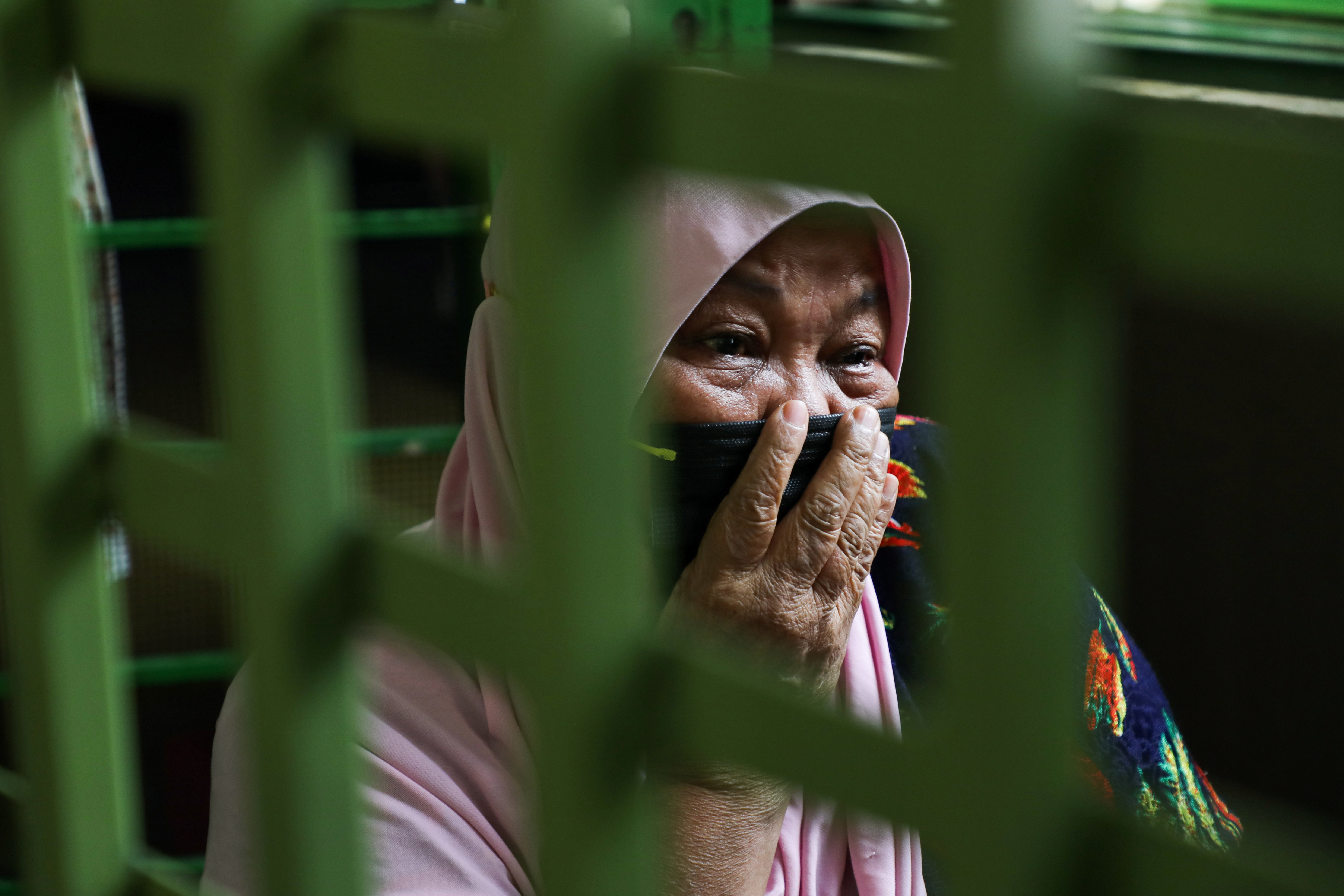 Halijah Naemat, 74, cries while members of public come over to help after she hung a white flag outside her home during an enhanced lockdown in Petaling Jaya