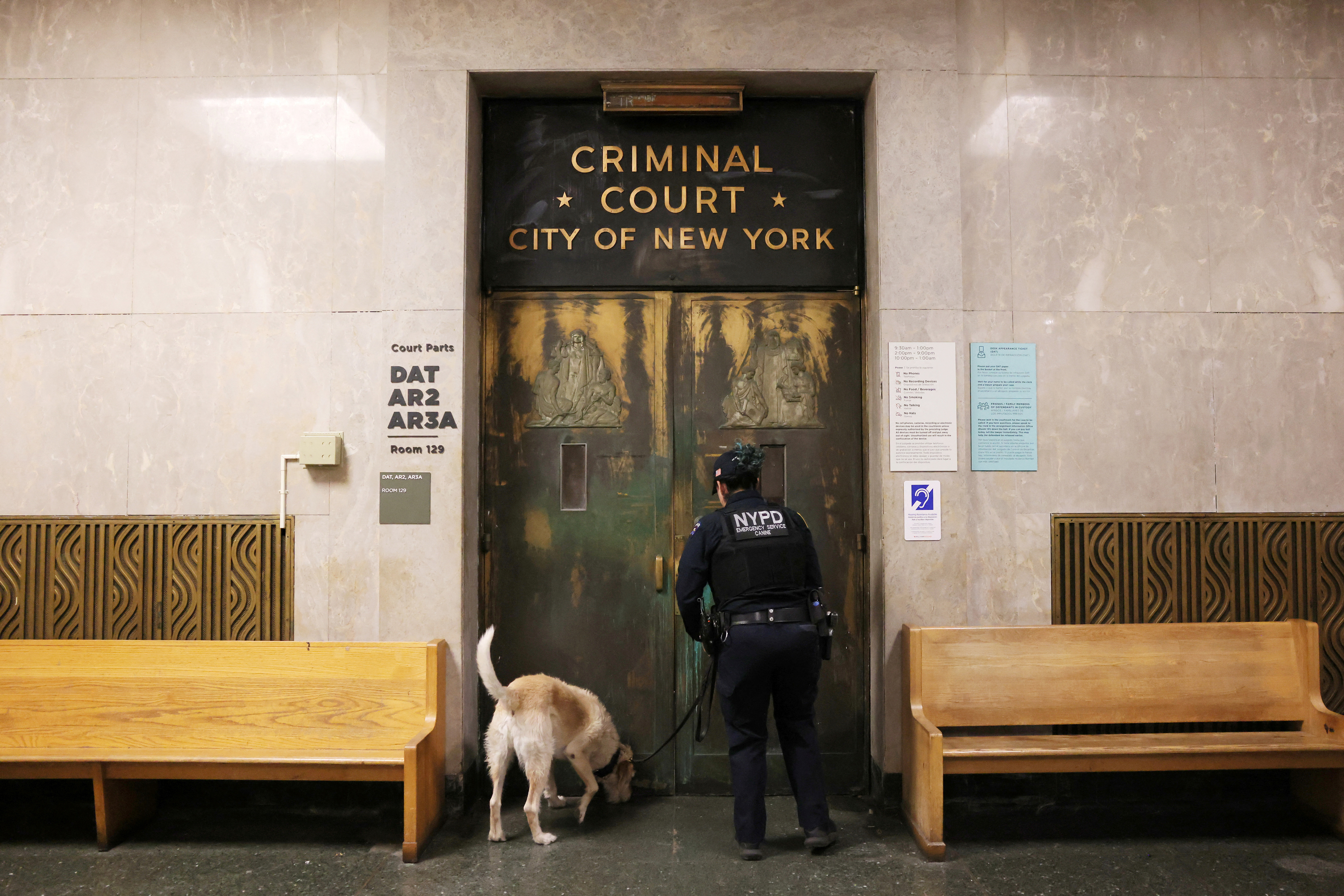 An officer from the New York City Police Department (NYPD) Canine Unit checks outside the Manhattan Criminal Court in New York City