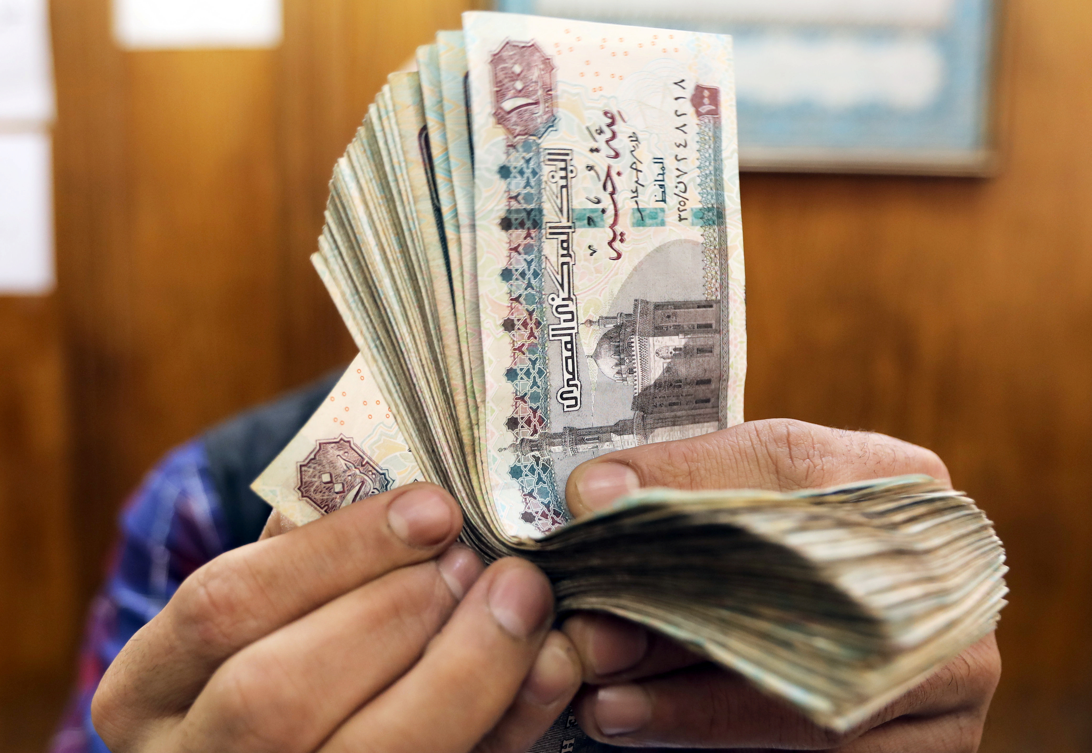 An employee counts Egyptian pounds at a foreign exchange office in central Cairo