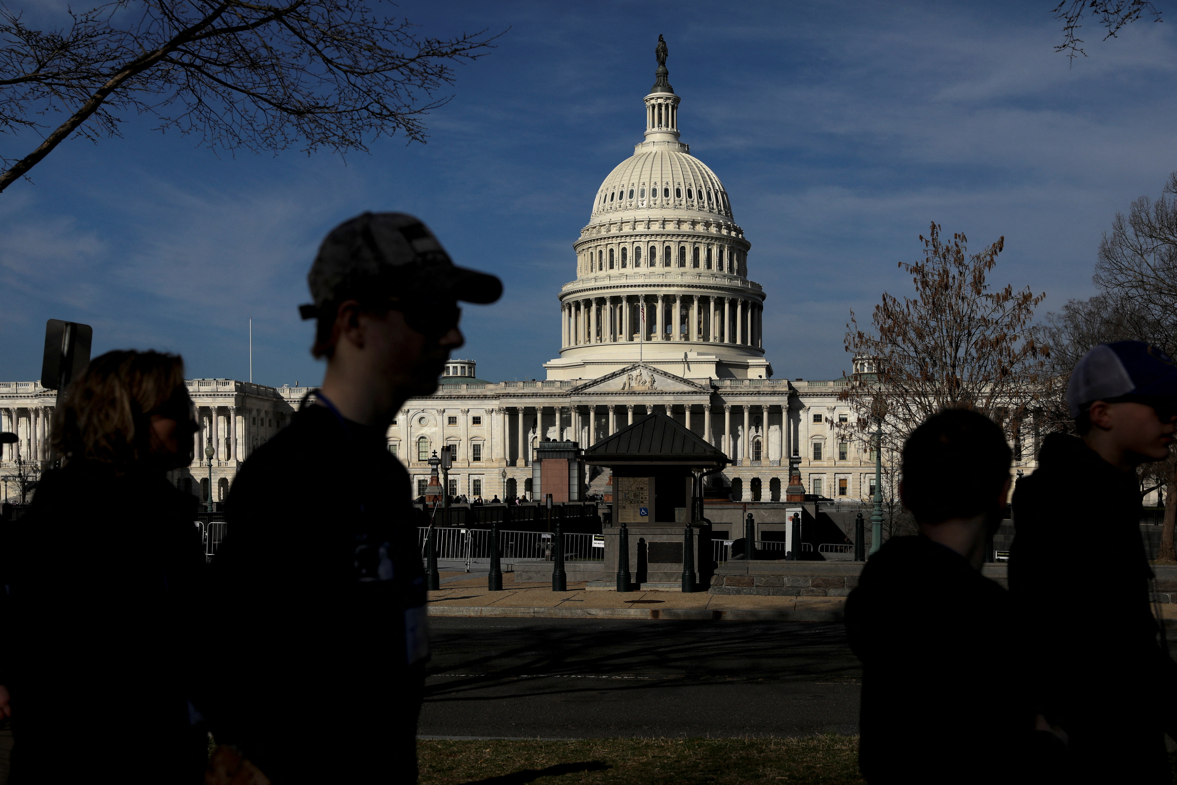 Pedestrians walk by the United States Capitol building in Washington