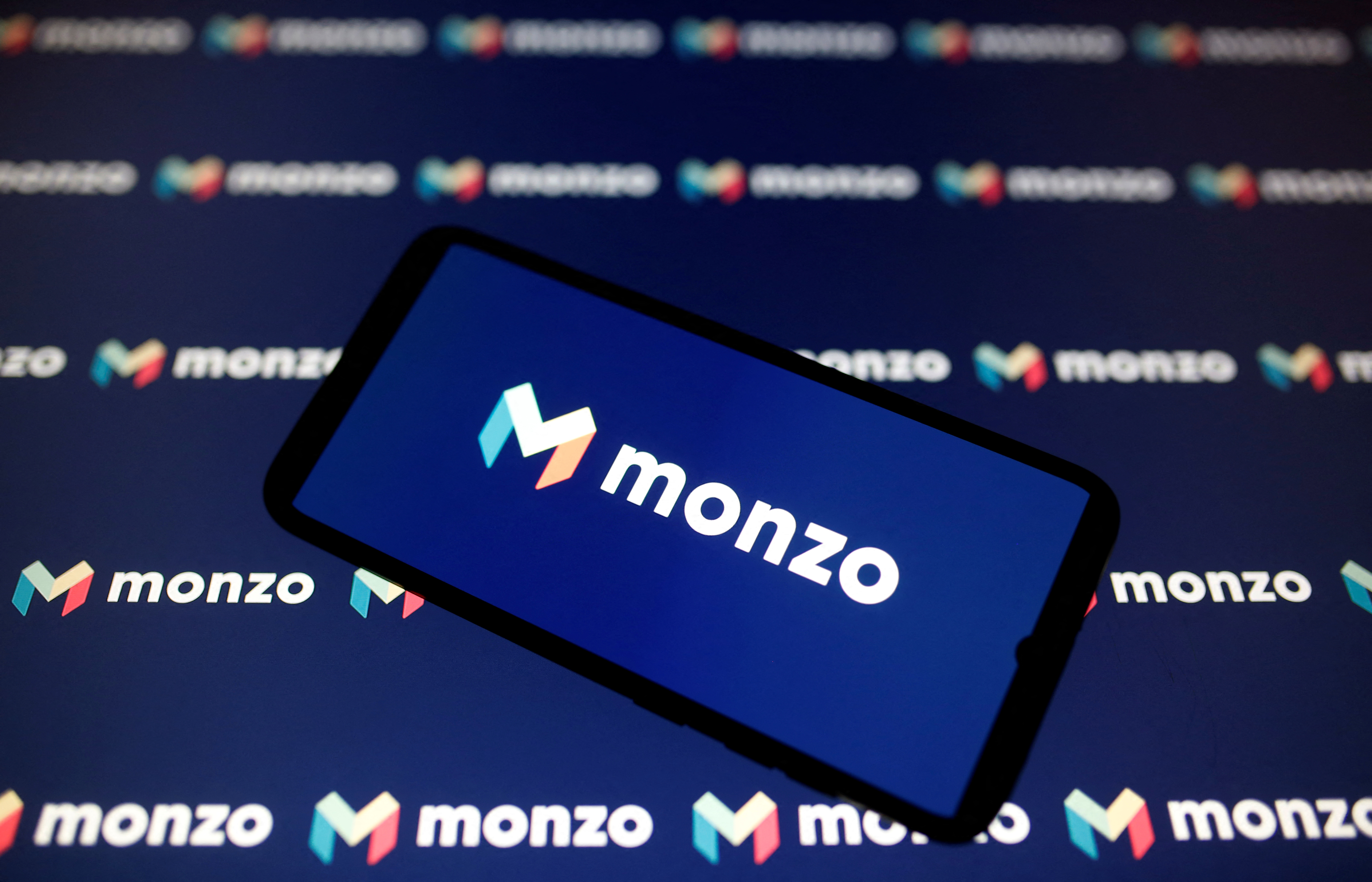 A smartphone displays a Monzo logo in this illustration