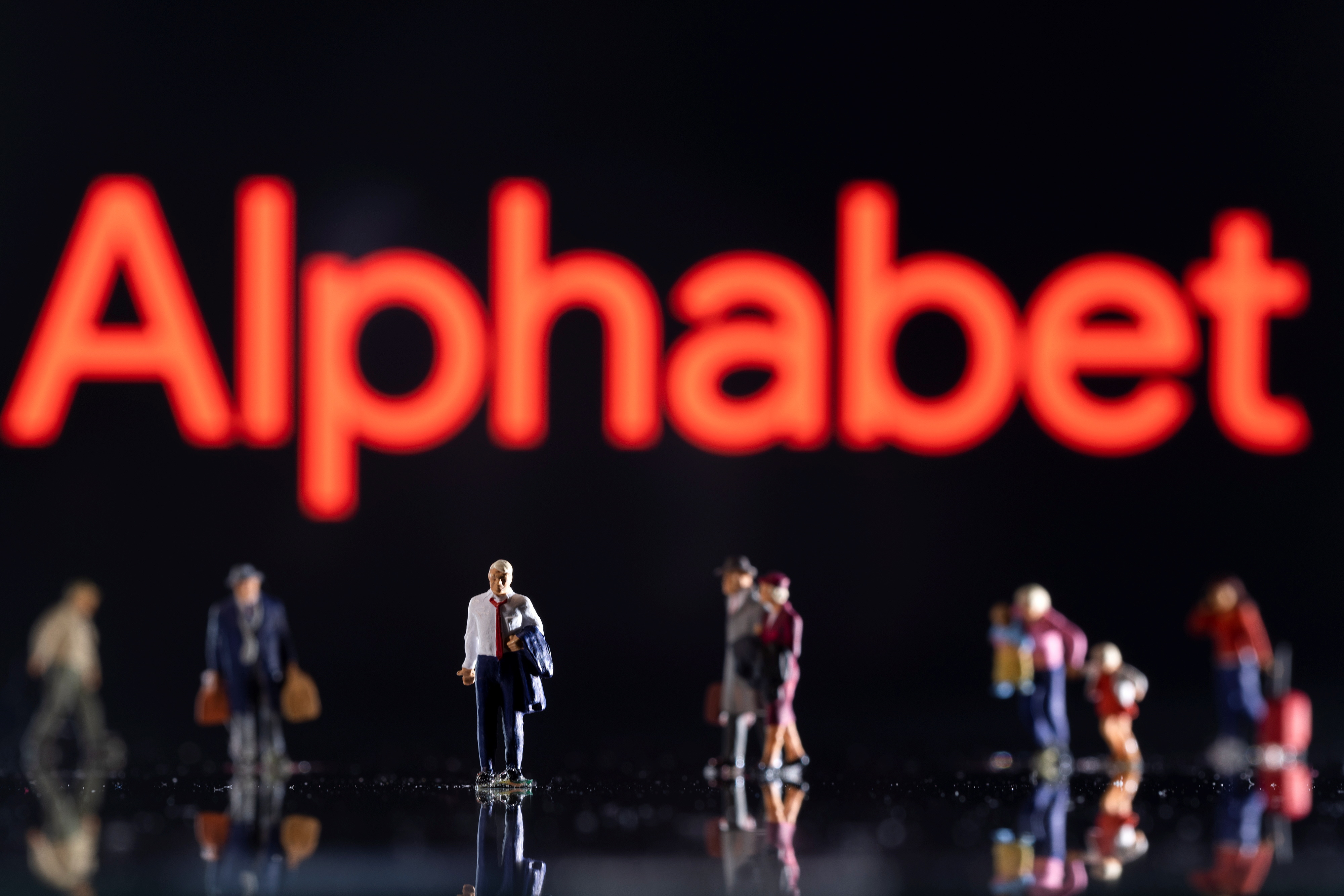 Illustration shows small figurines and displayed Alphabet logo