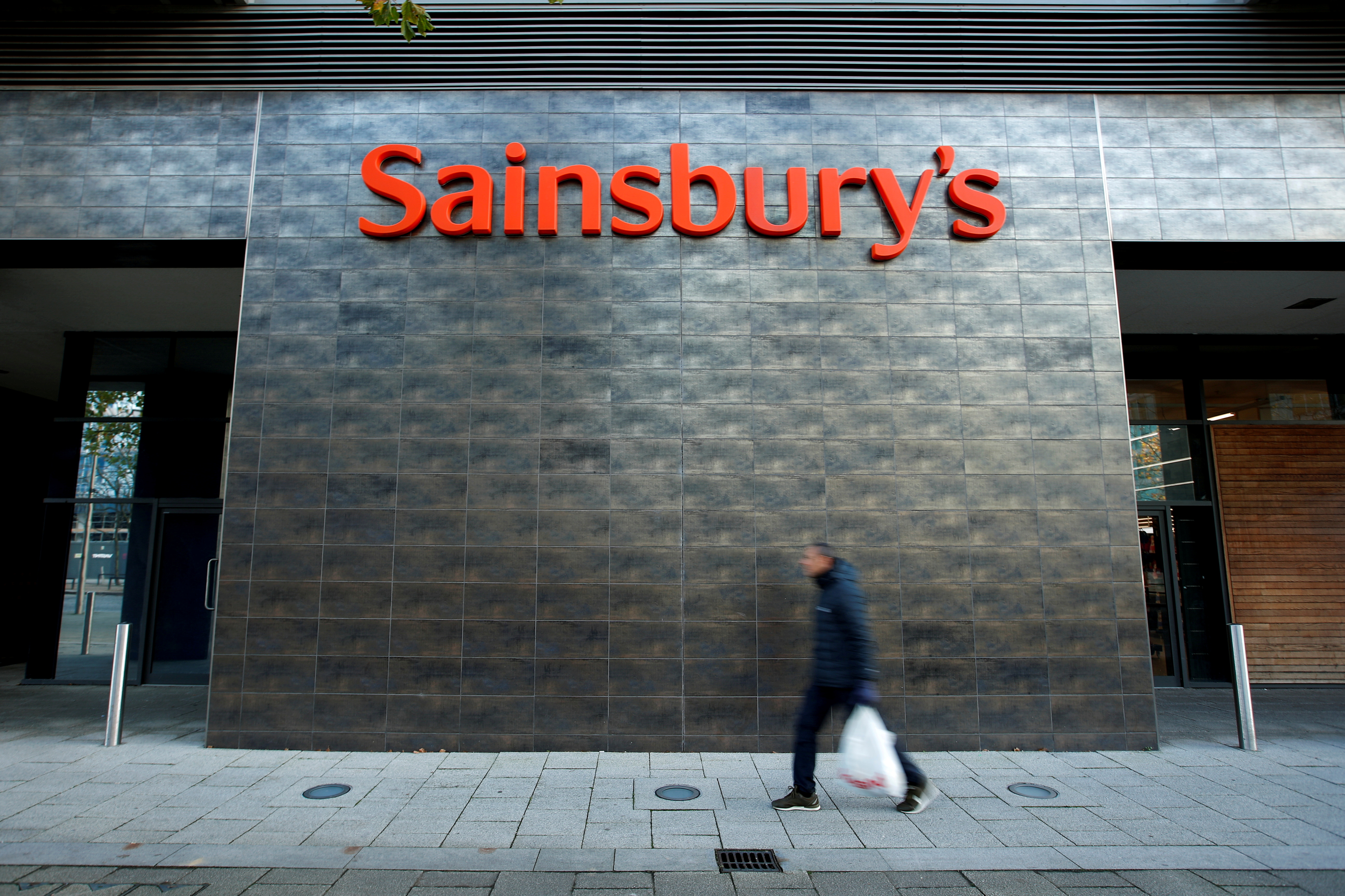 A person walks past a Sainsbury's store in Milton Keynes, Britain November 5, 2020. REUTERS/Andrew Boyers
