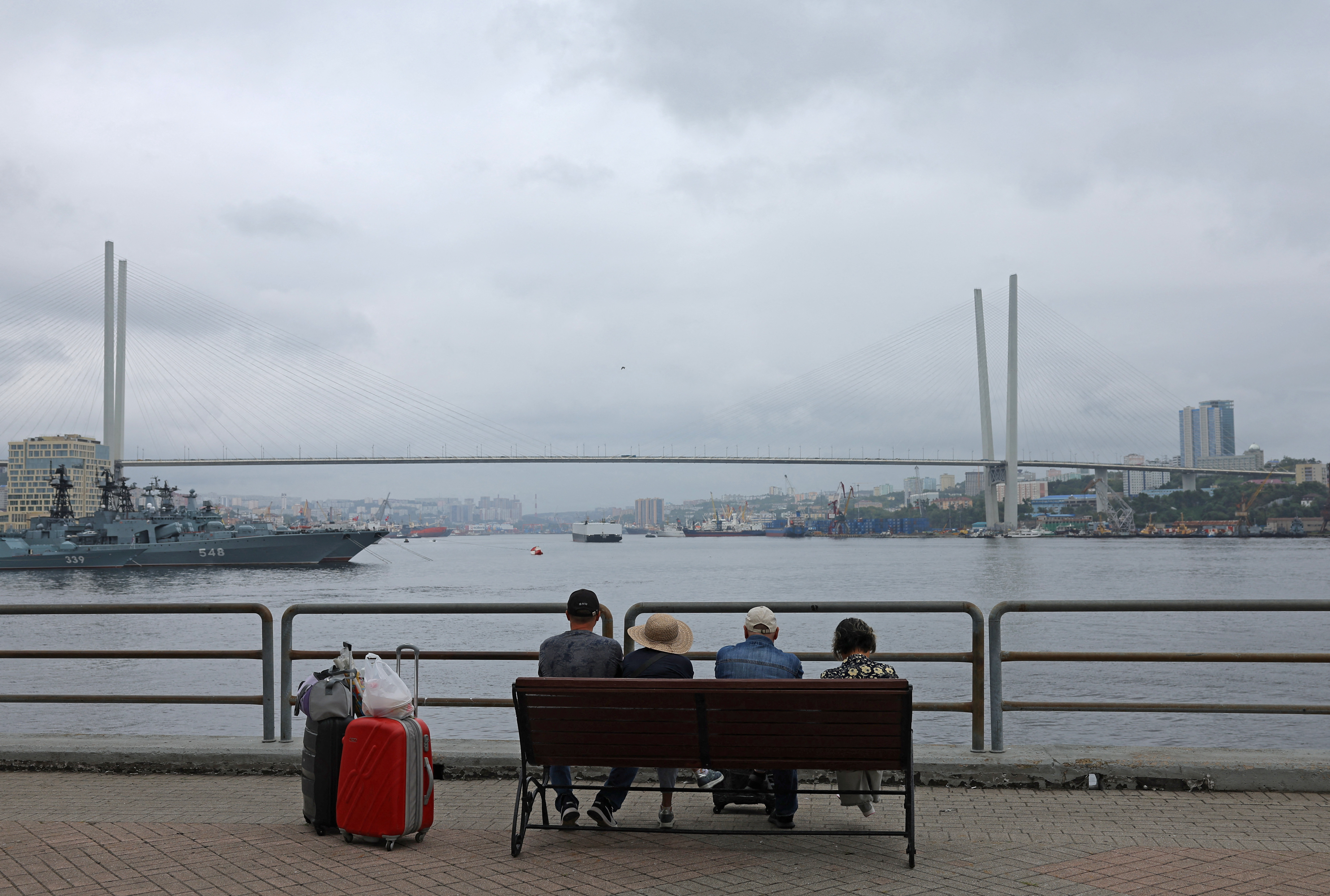 People sit on a bench on an embankment in Vladivostok