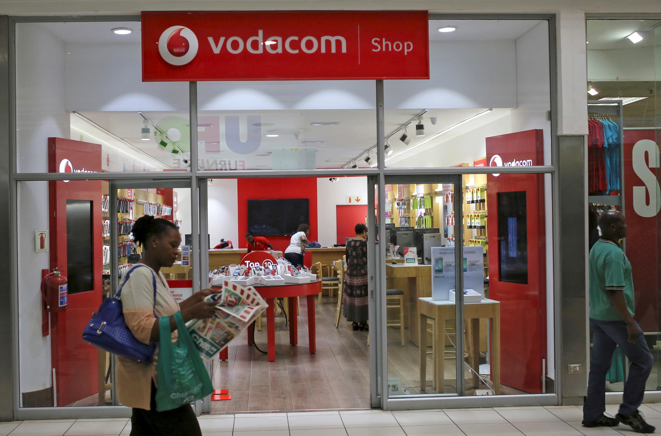 A shopper walks past a Vodacom shop in Johannesburg February 4, 2015. REUTERS/Siphiwe Sibeko