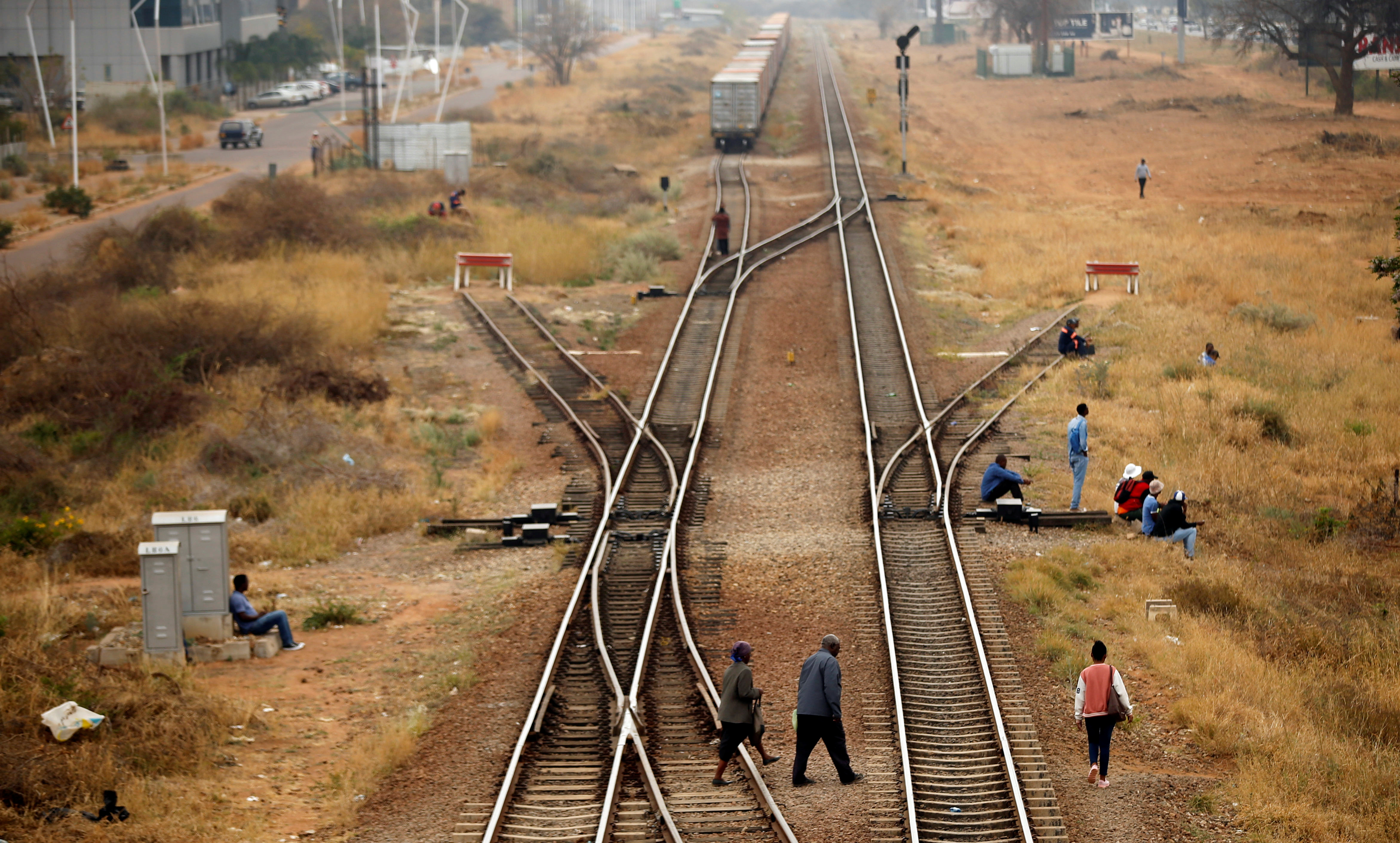 People cross rail tracks in the Central Business District (CBD), in the capital Gaborone
