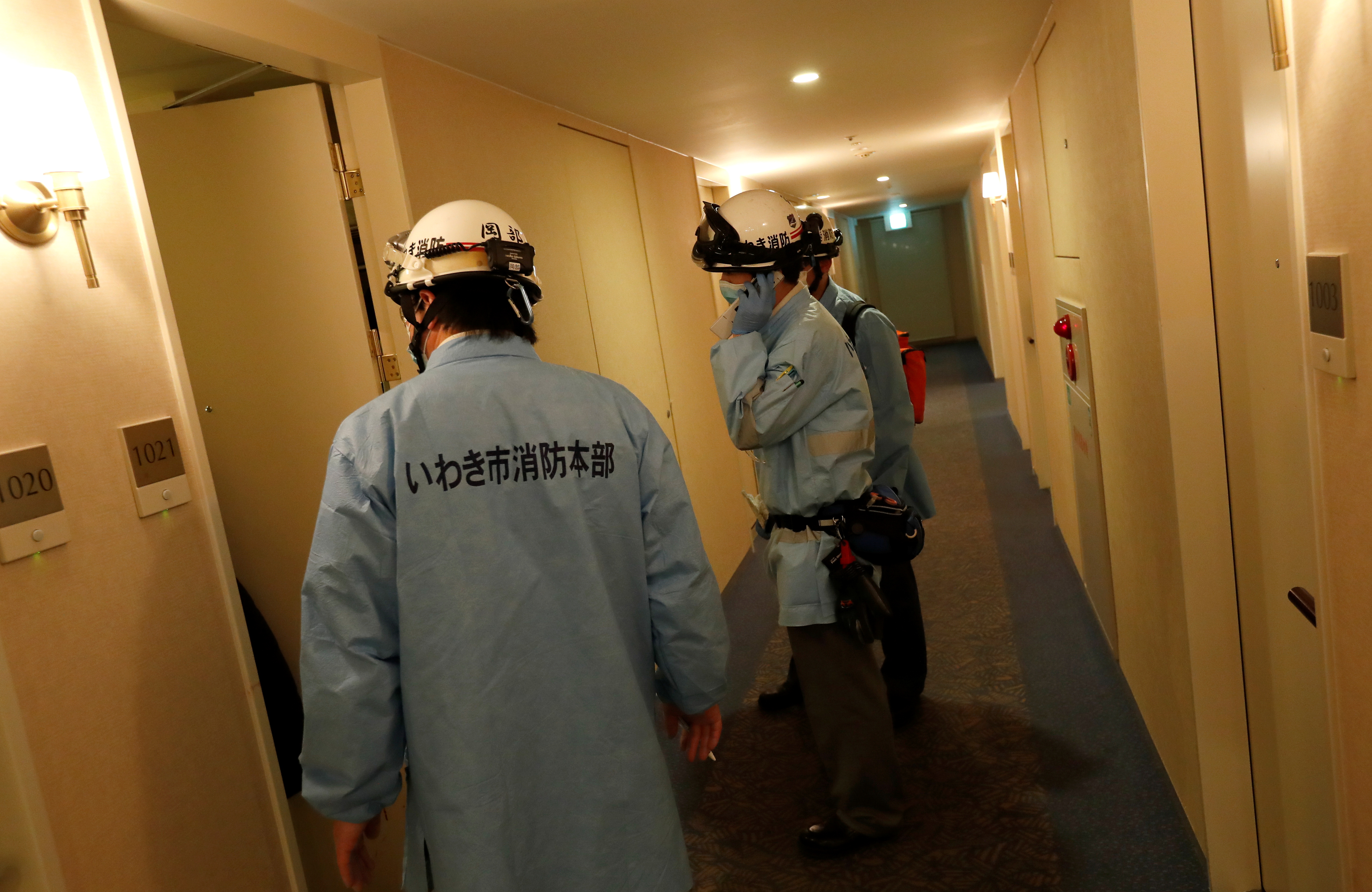 Ambulance crew members stand in the hotel corridor following a strong earthquake in Iwaki, Fukushima prefecture, Japan February 13, 2021.  REUTERS/Issei Kato