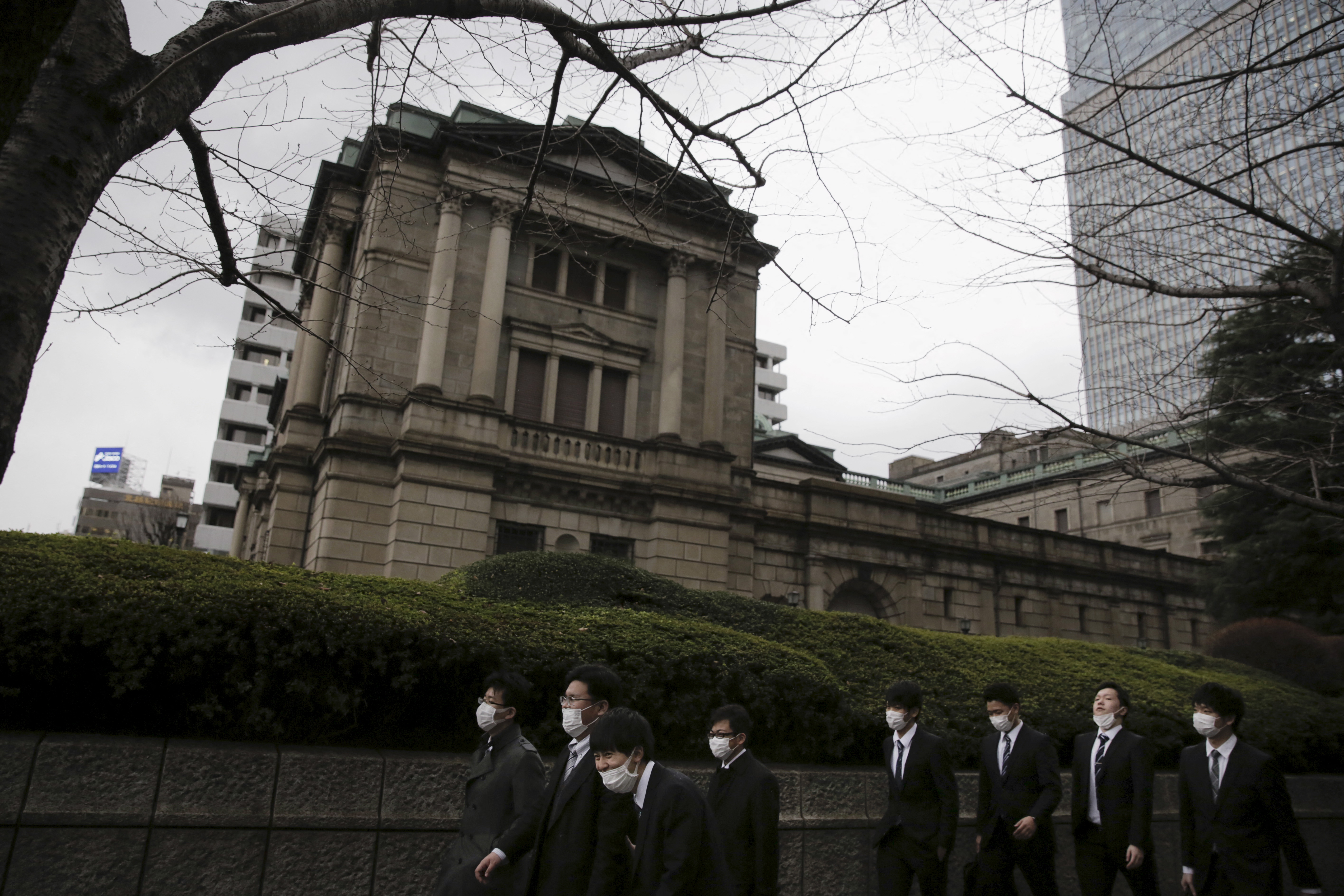 Businessmen walk past the Bank of Japan headquarters in Tokyo
