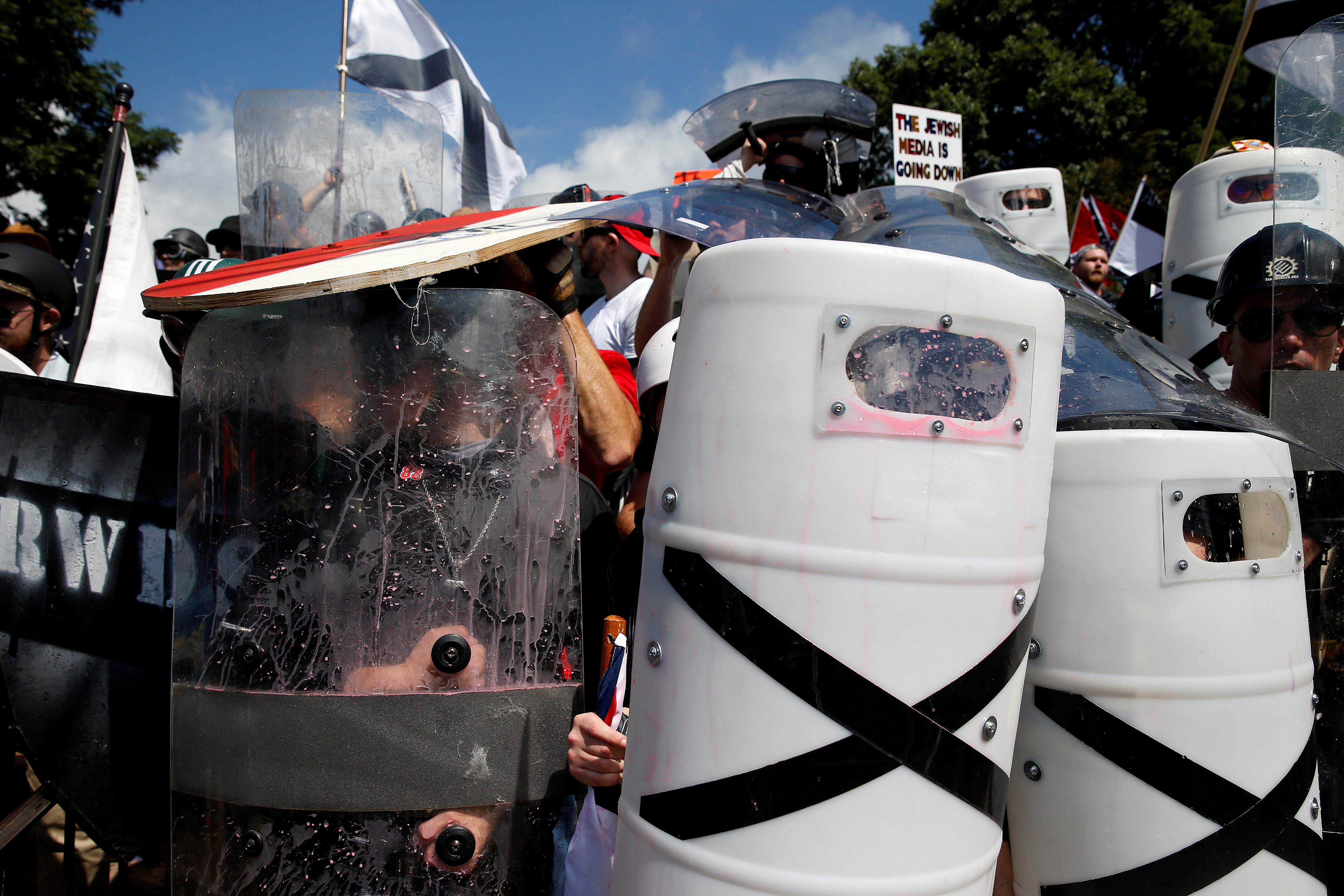 White nationalists shelter behind their shields after clashing with counter protesters at a rally in Charlottesville, Virginia
