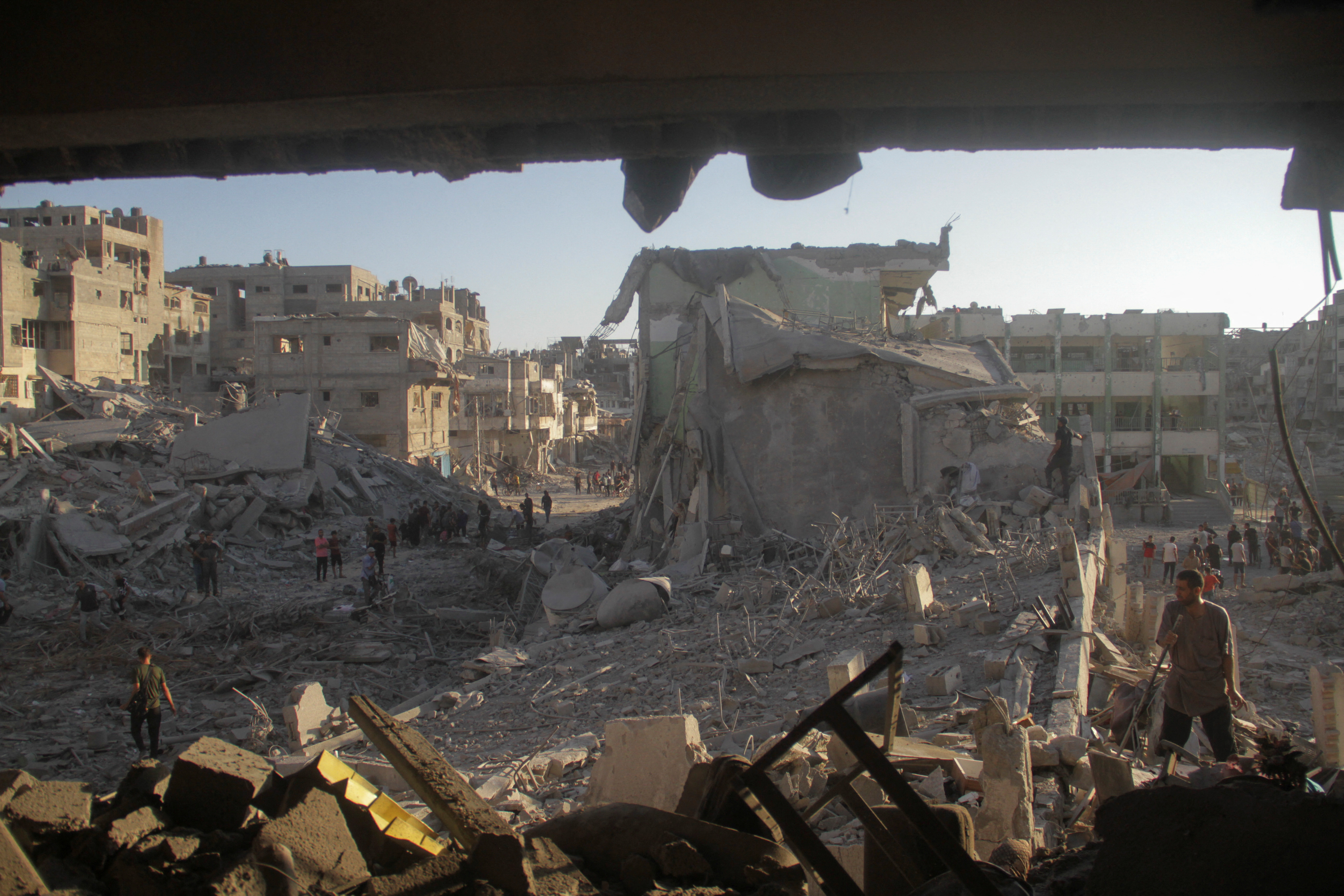 Palestinians inspect the site of Israeli strikes on a school sheltering displaced people, amid Israel-Hamas conflict, in Gaza City