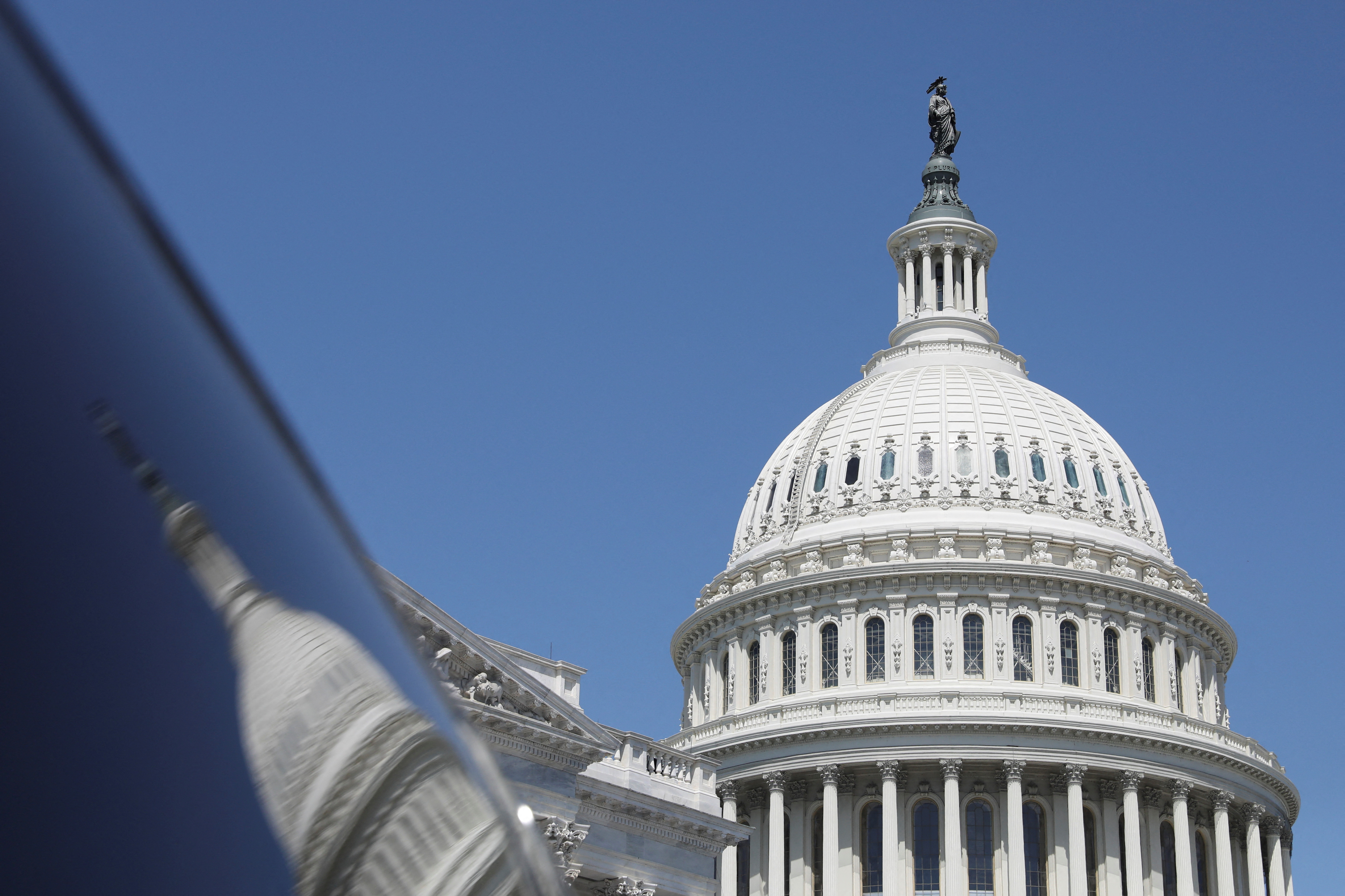 The dome of the U.S. Capitol is reflected in a window on Capitol Hill in Washington