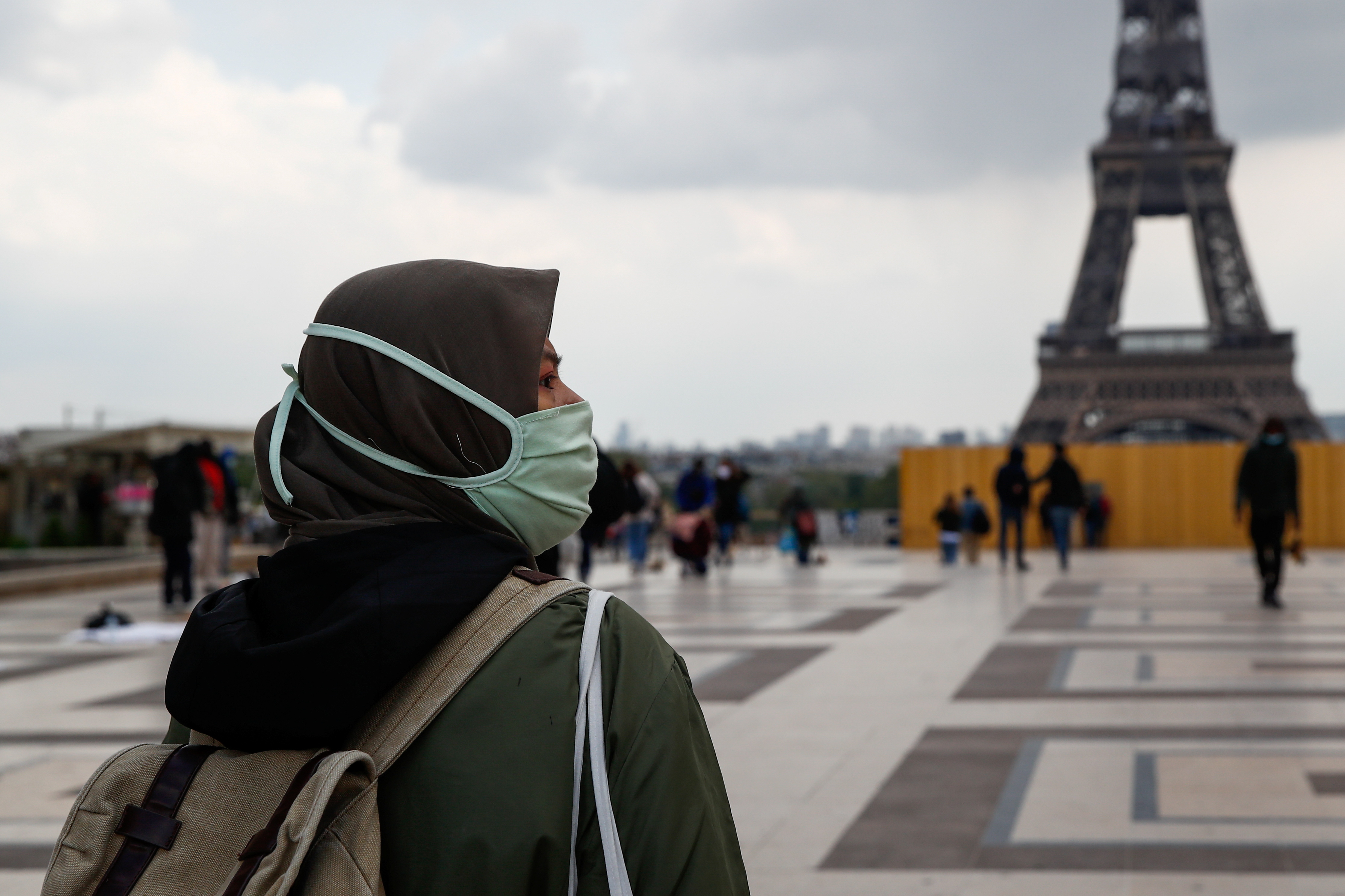 A woman wearing a hijab walks at Trocadero square near the Eiffel Tower in Paris